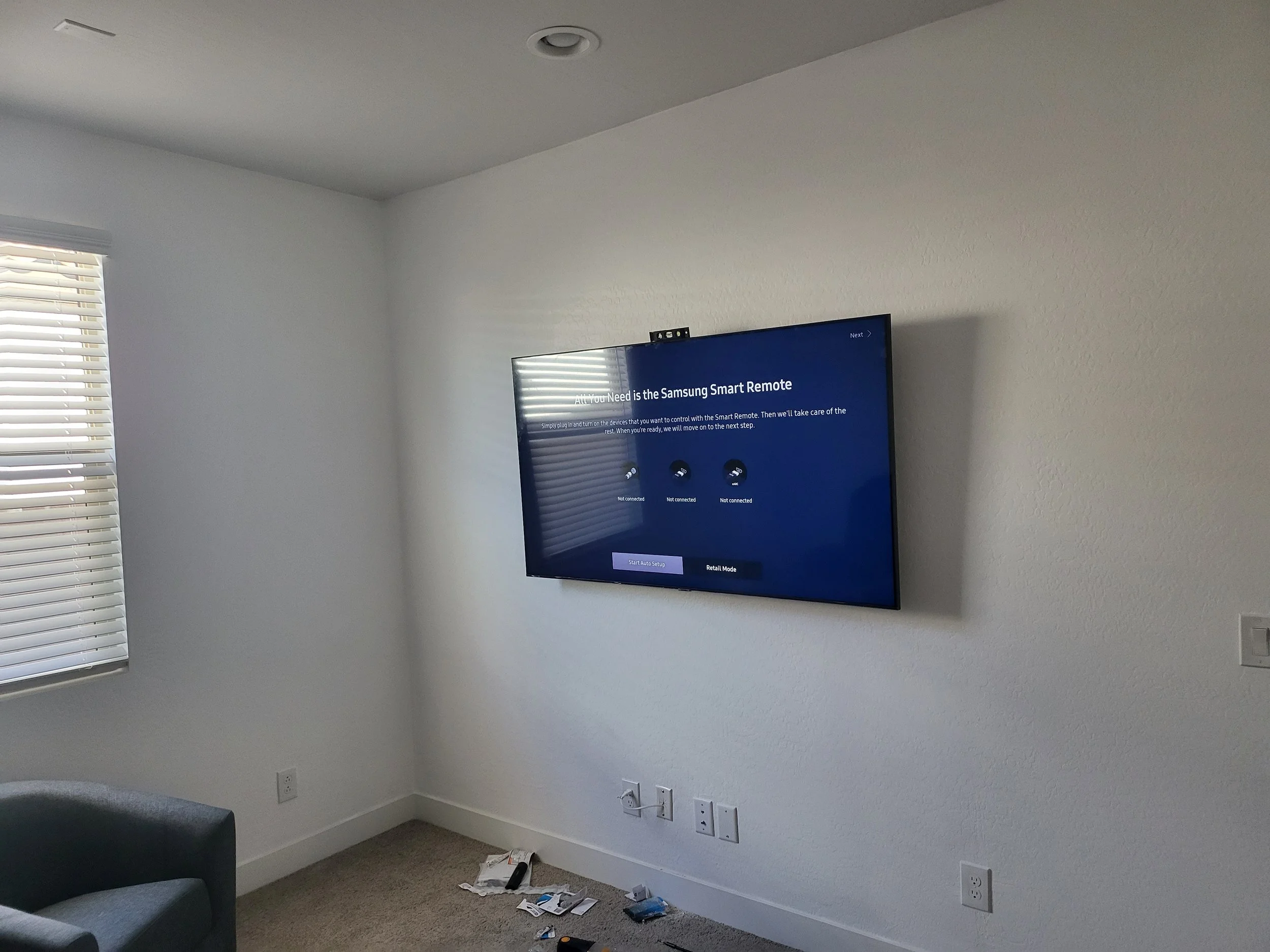 Flat-screen TV securely mounted on drywall featuring complete hidden wire routing and clean cord management by Helping Hands Household Solutions.