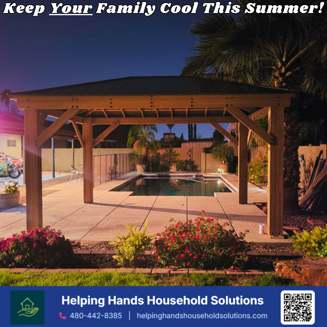Wood-framed hardtop gazebo with a solid shingled roof, installed poolside at dusk in a landscaped Phoenix, AZ backyard by Helping Hands Household Solutions.