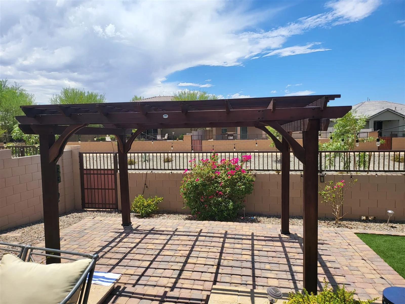 Shade with style: dark stained wood pergola over pavers