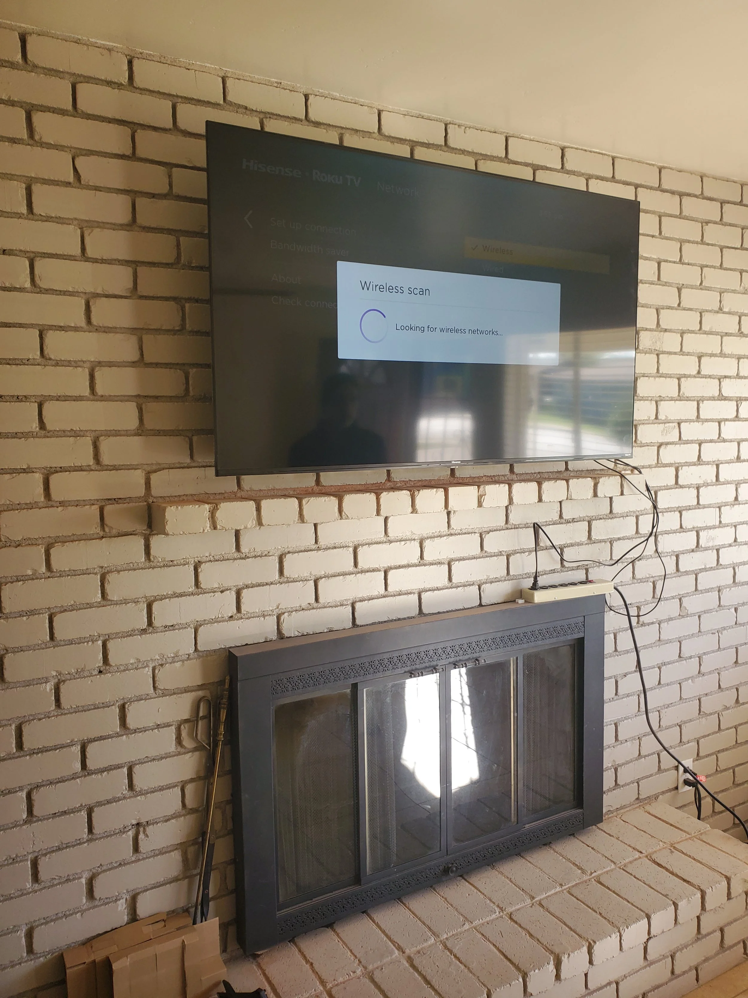 Phoenix living room setup: TV wall-mounted on a tan brick fireplace surround above a black fireplace insert.