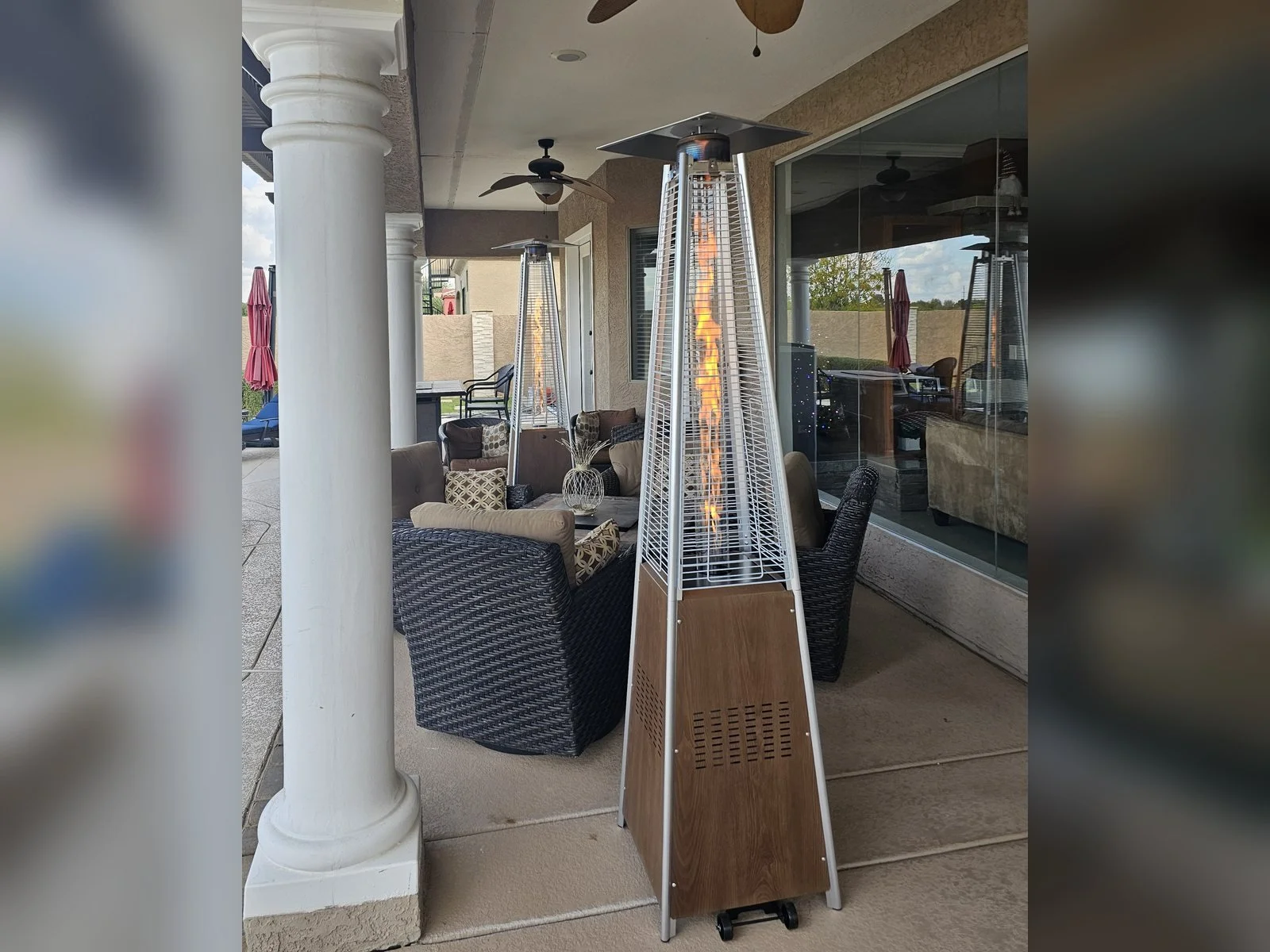 Pyramid propane patio heaters assembled and lit on a covered backyard patio by Helping Hands in Phoenix AZ