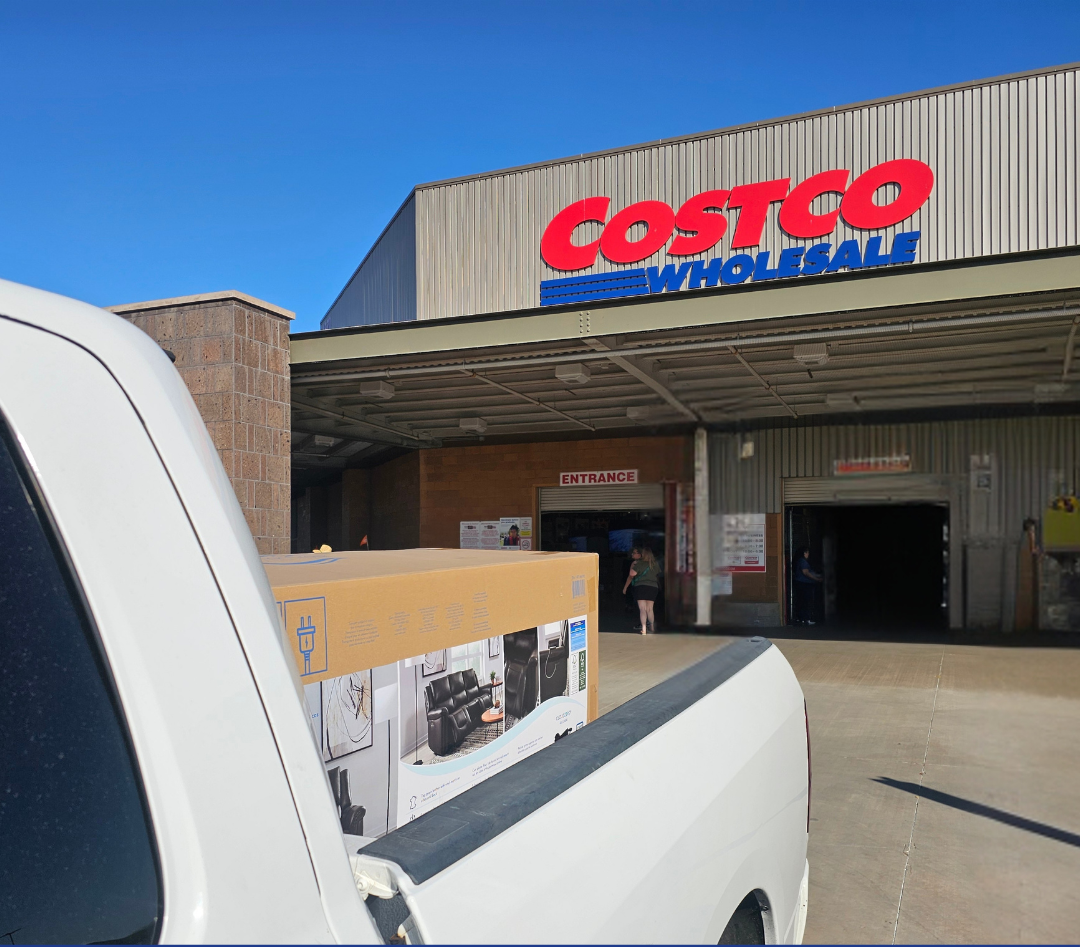 Helping Hands Household Solutions' careful movers picking up a leather reclining couch for a customer at Costco so it can be delivered.