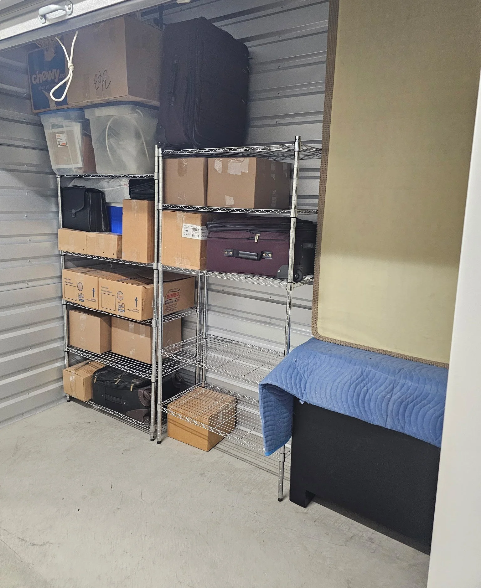 Storage unit swap finished with boxes and luggage neatly placed on wire shelves in San Tan Valley, AZ