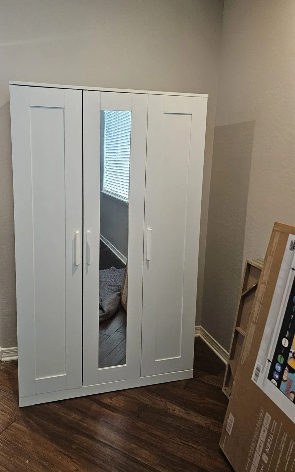 White three-door wardrobe with mirror assembled in a Phoenix home