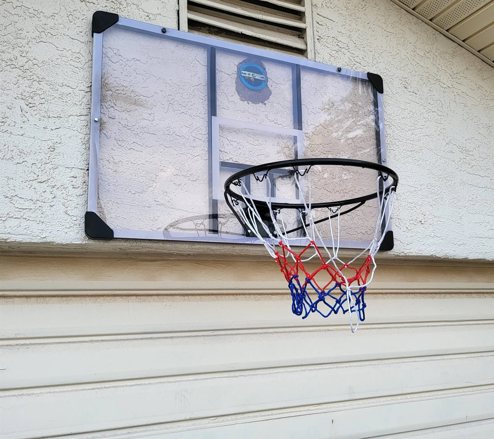 Wall-mounted basketball hoop installed above a garage door in Peoria