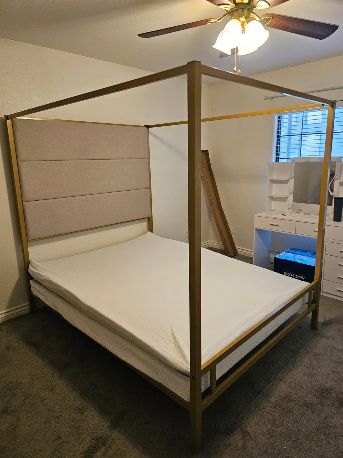 Gold metal canopy bed frame assembled in a Phoenix bedroom