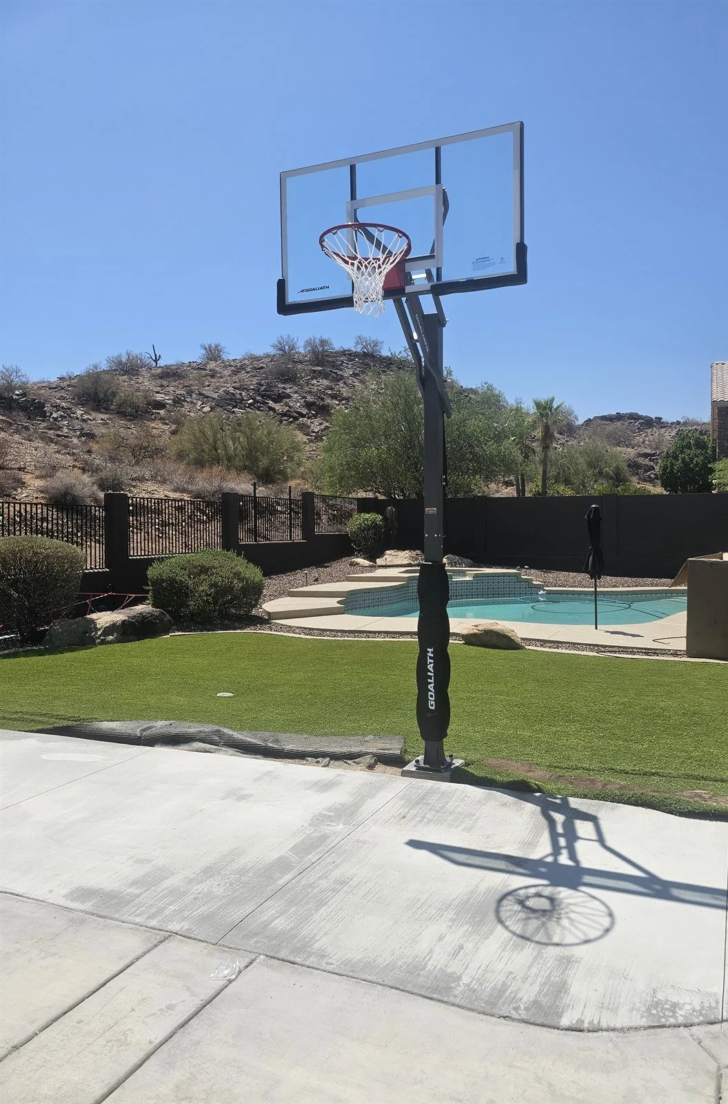In-ground basketball goal installed beside a backyard pool with desert mountain views in Cave Creek