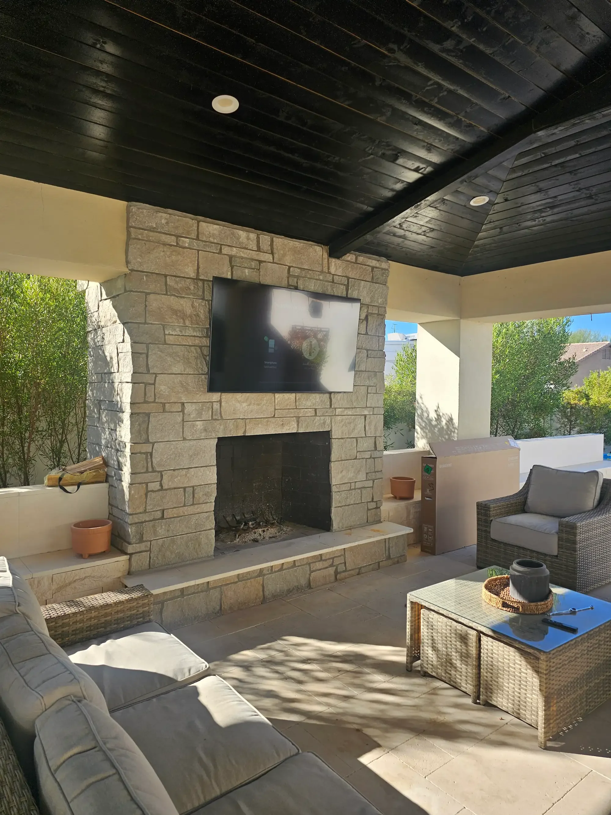 TV mounted above an outdoor fireplace on a covered patio in Phoenix, AZ