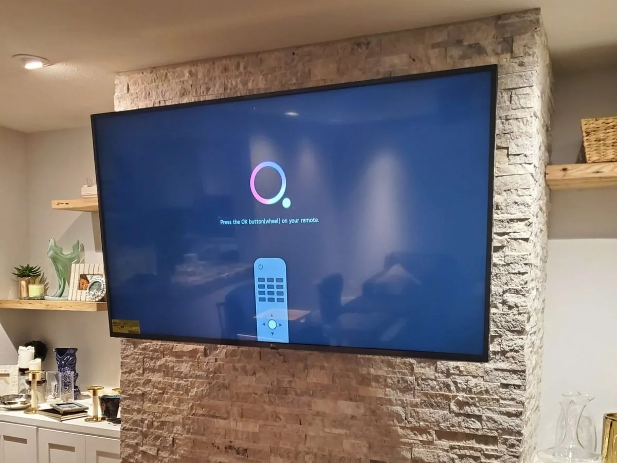 Large TV wall mounted on a stacked stone fireplace in a Phoenix home