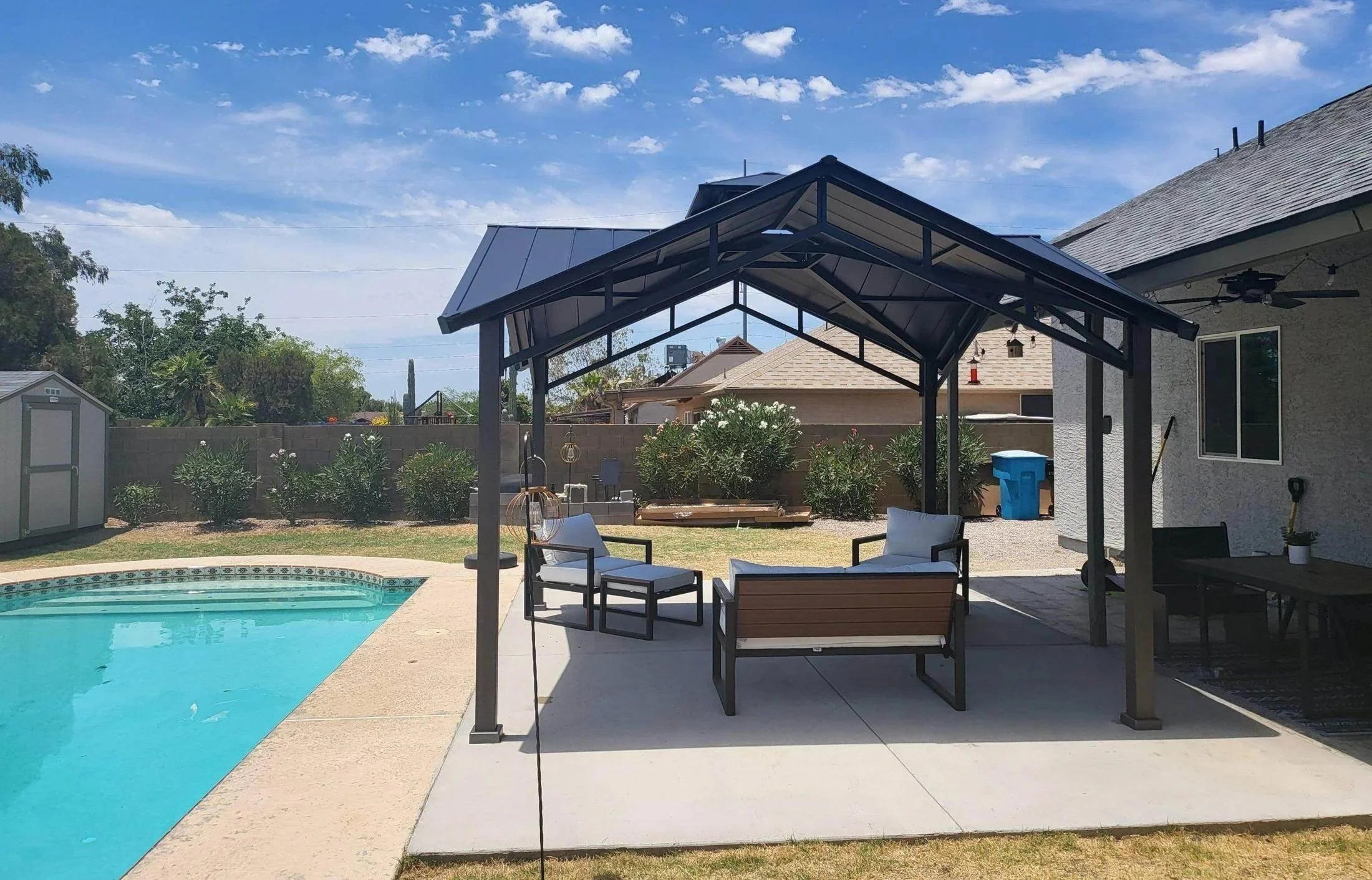 Completed backyard gazebo installation beside a residential pool by Helping Hands Household Solutions.