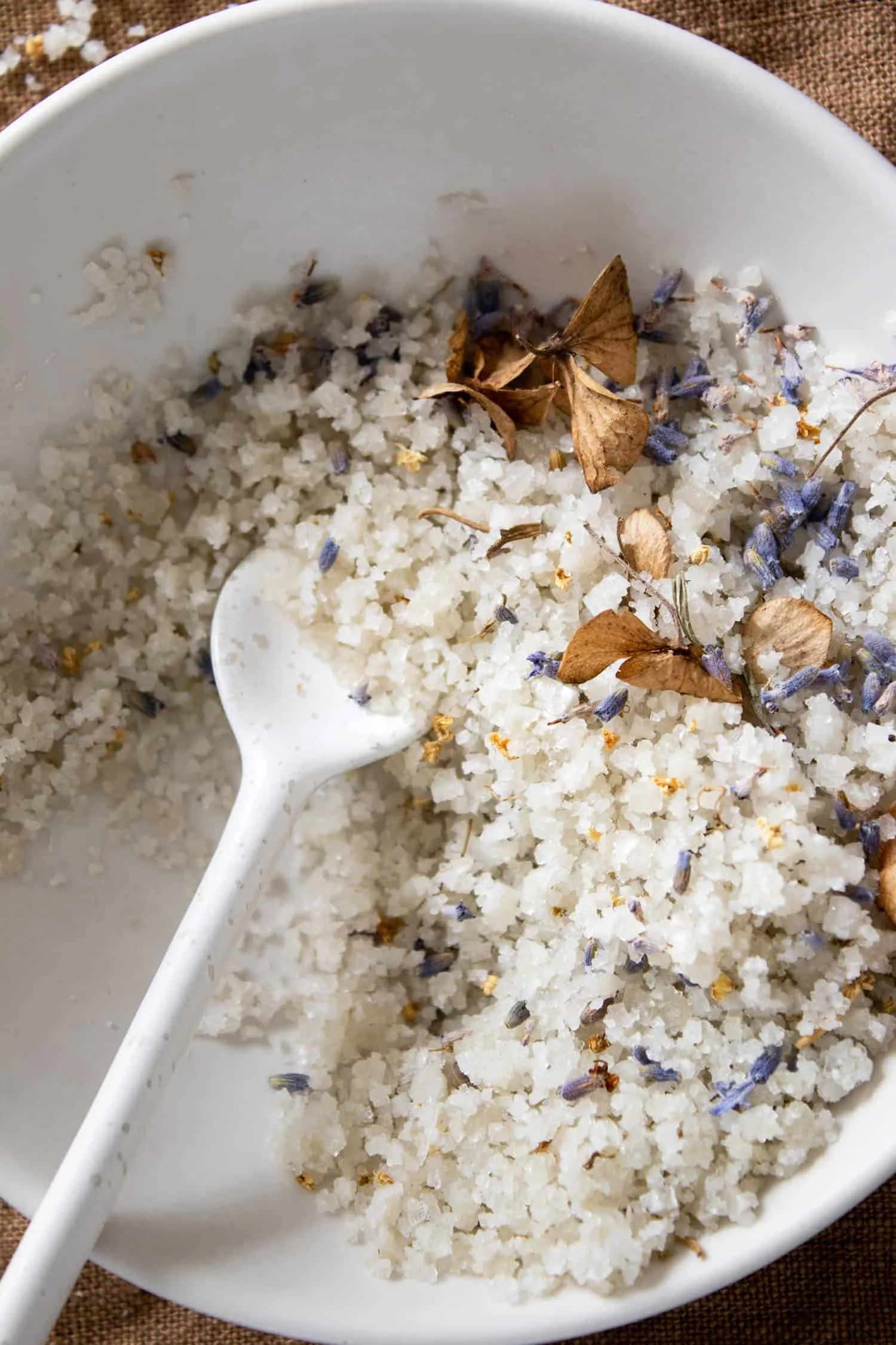 Close up picture of bath salts with dried flowers in a bowl