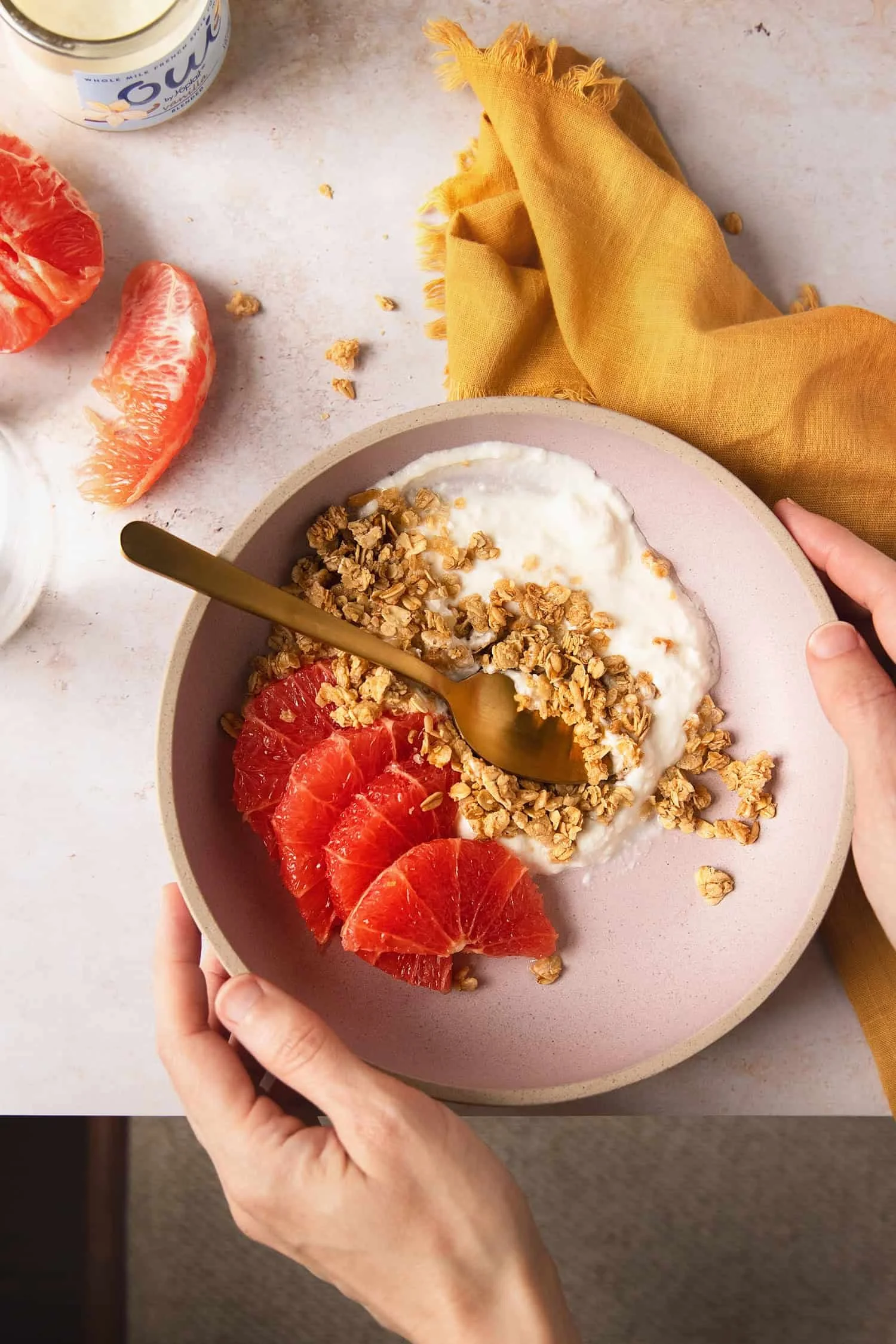 Overhead photo of Oui yogurt in a bowl with granola and grapefruit