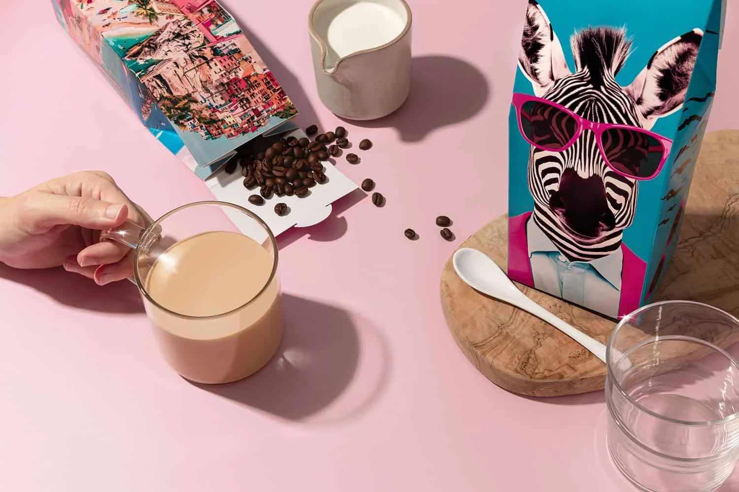Coffee product photo with a hand holding a coffee mugs surrounded by bags or coffee beans