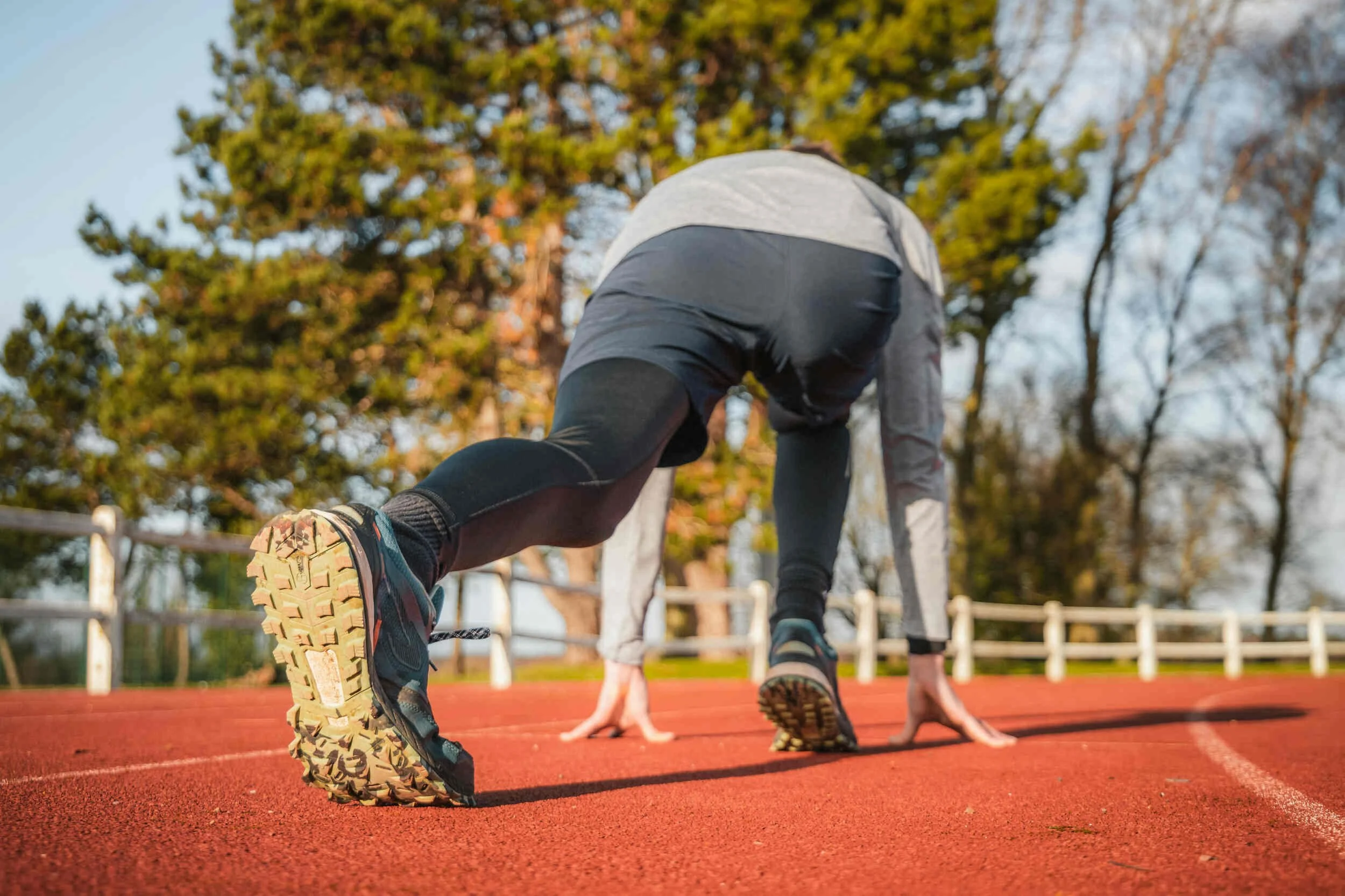 A man getting ready to start running on a track outside - how to get unstuck in your career
