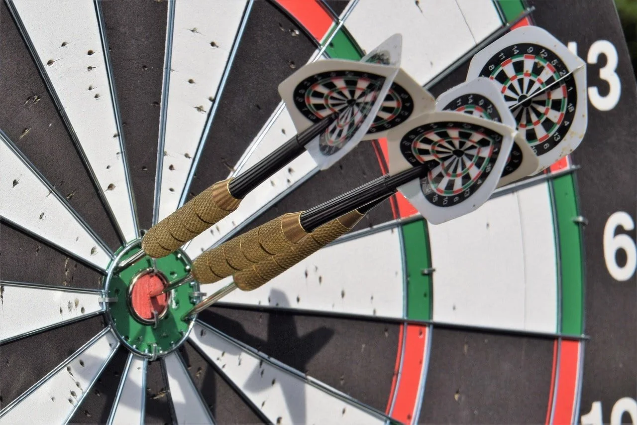 Three darts in or near the bullseye of a dart board - life and career coach Phoenix