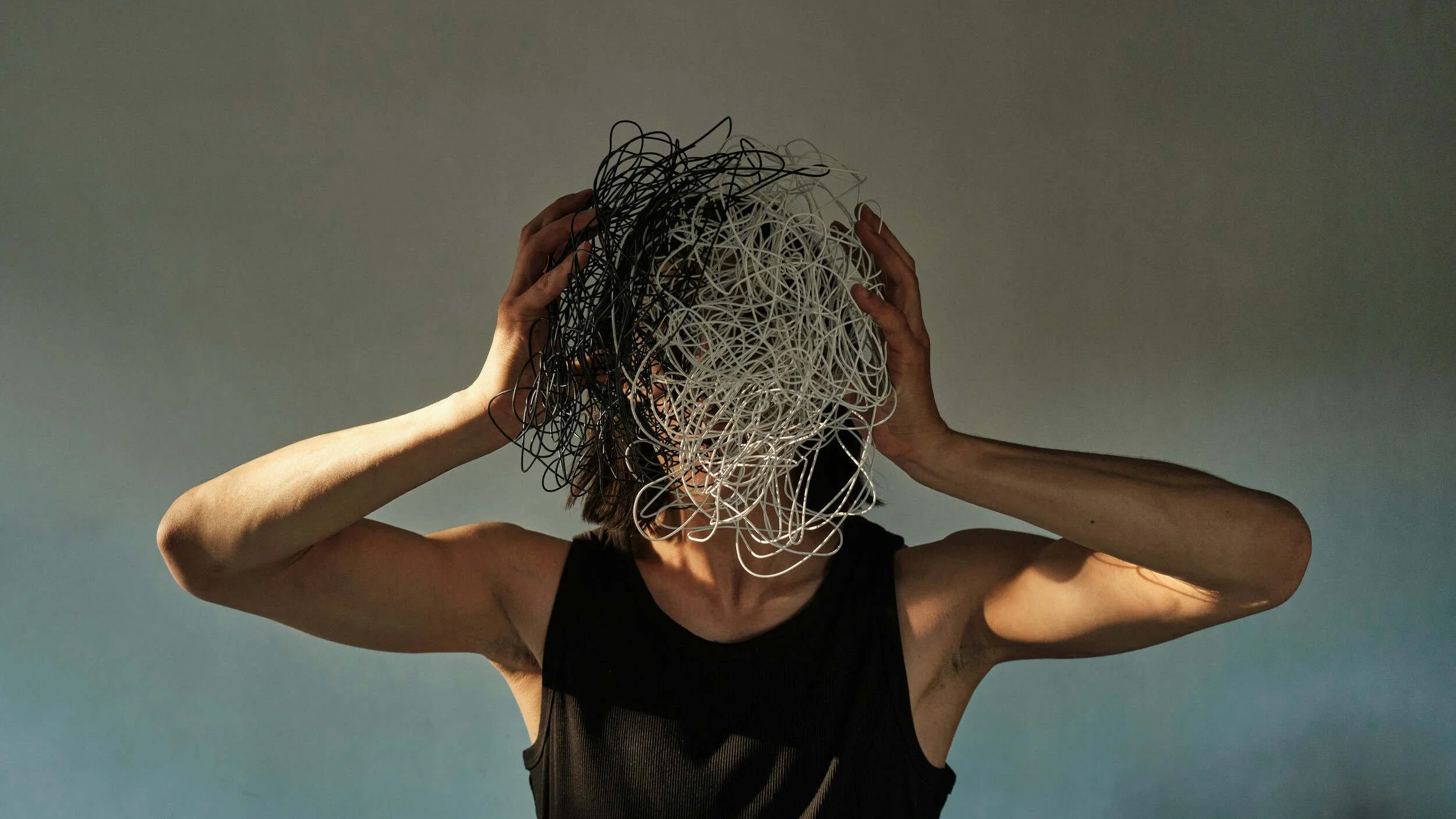A man with his face blocked by strings - burnout or career misalignment