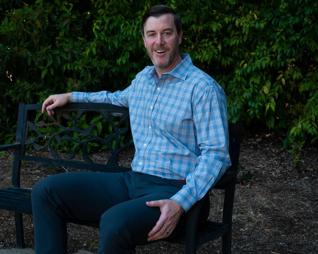 Jeff Rothenberg in a dress shirt sitting outside - confidence coach