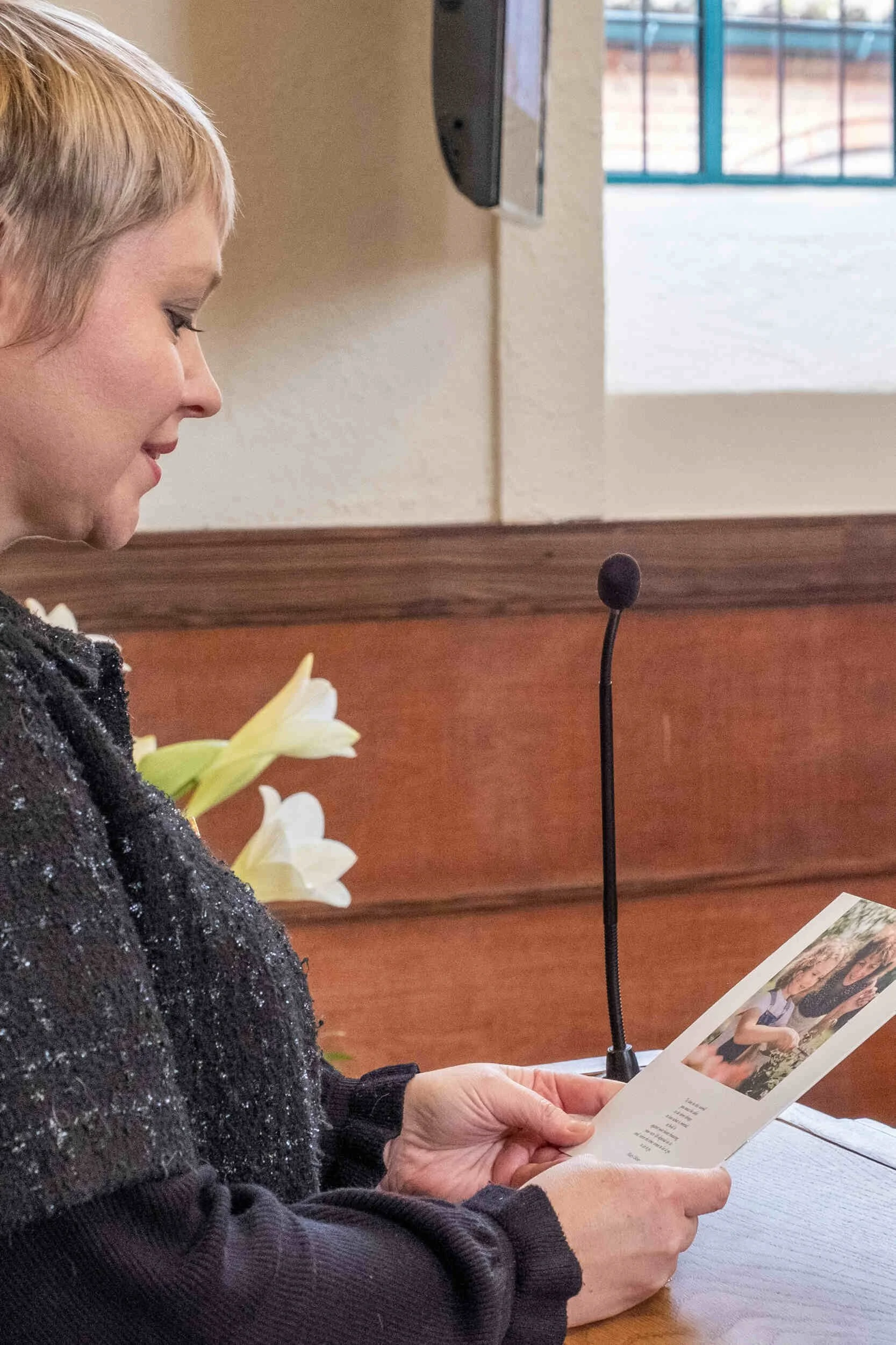 A women speaking at a podium holding a card with a picture on it - life coach Phoenix