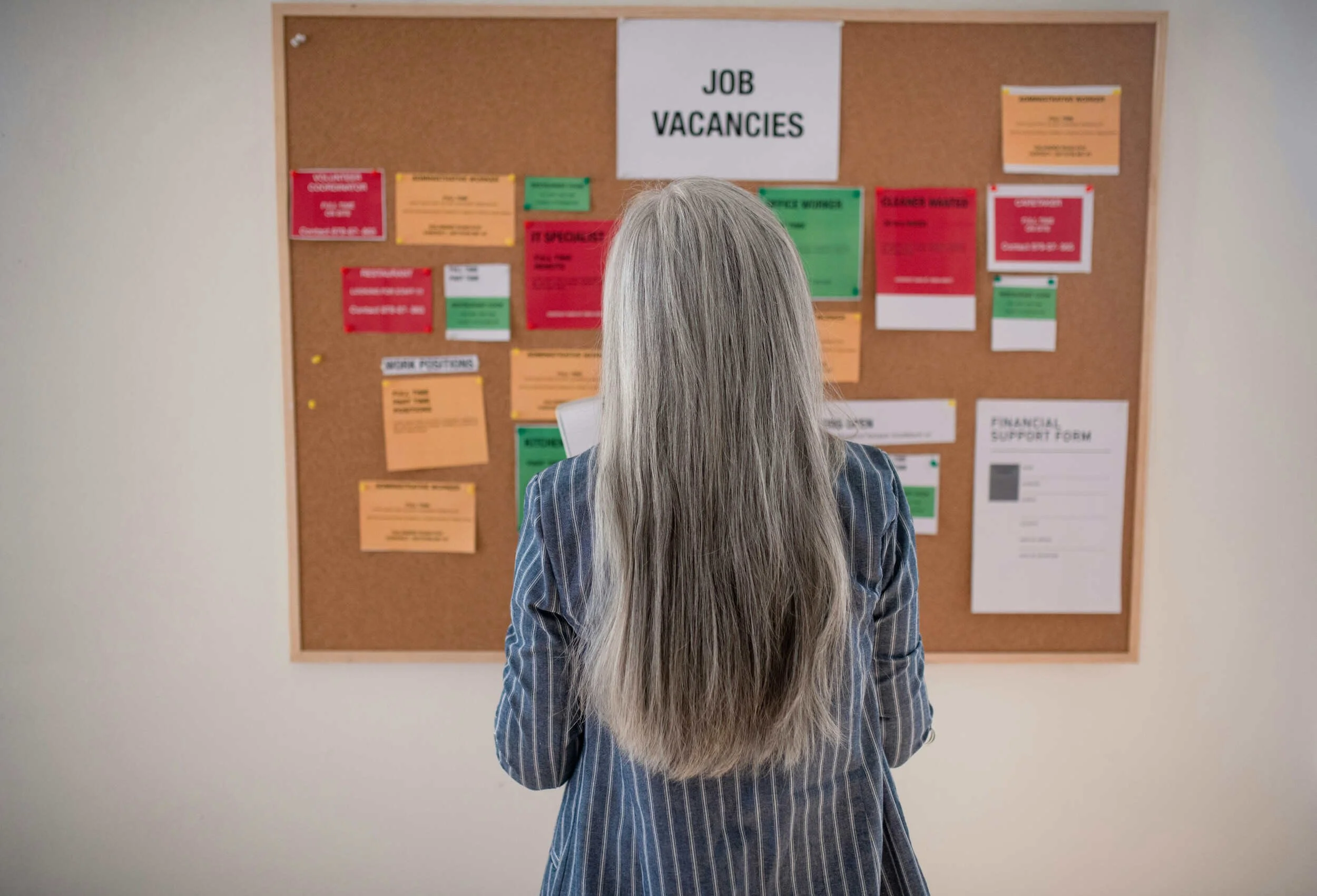 A women with long grey hair looking a job board - career change without starting over