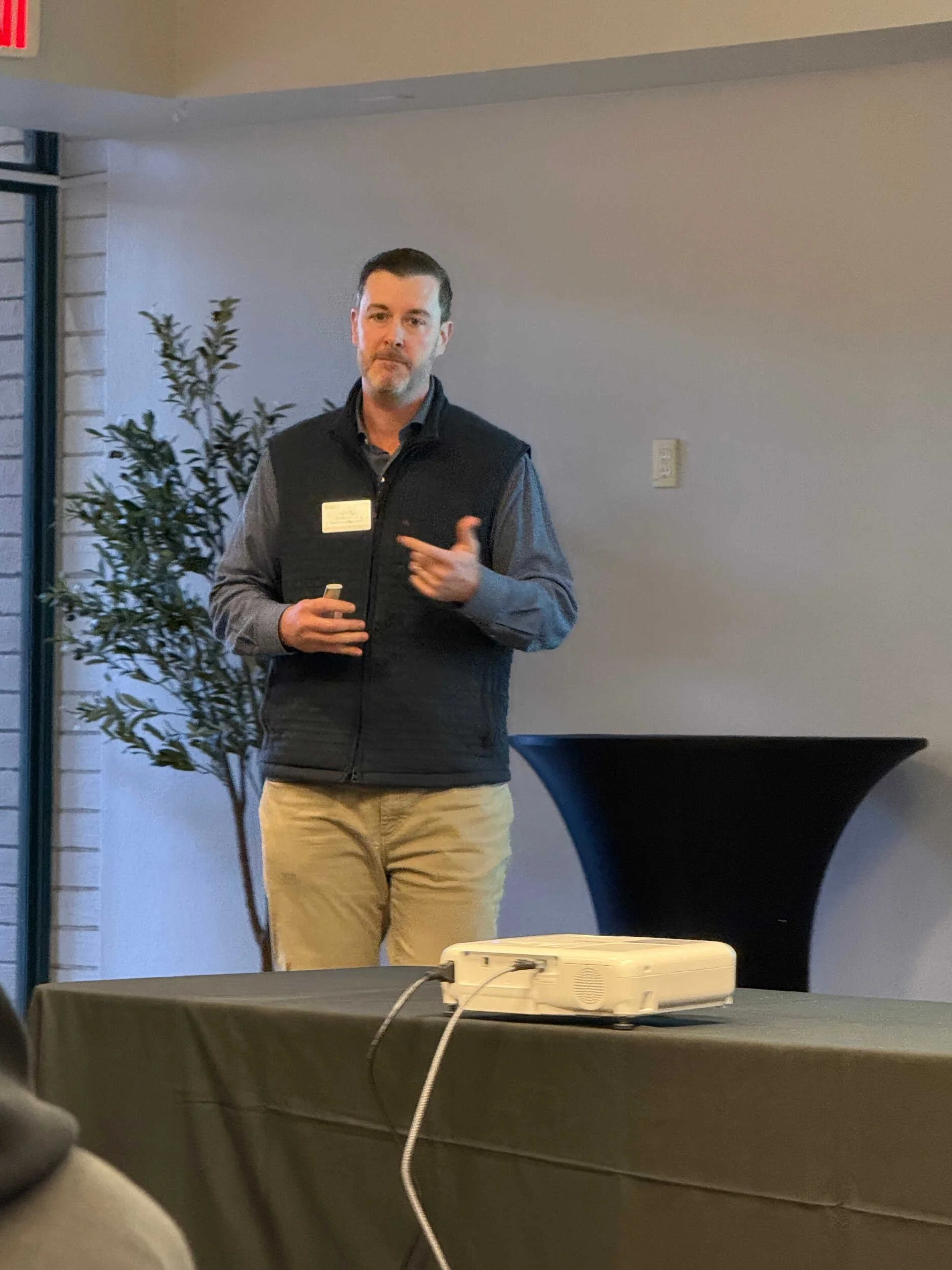 A handsome man with a vest on talking - career pivot from tech to coaching