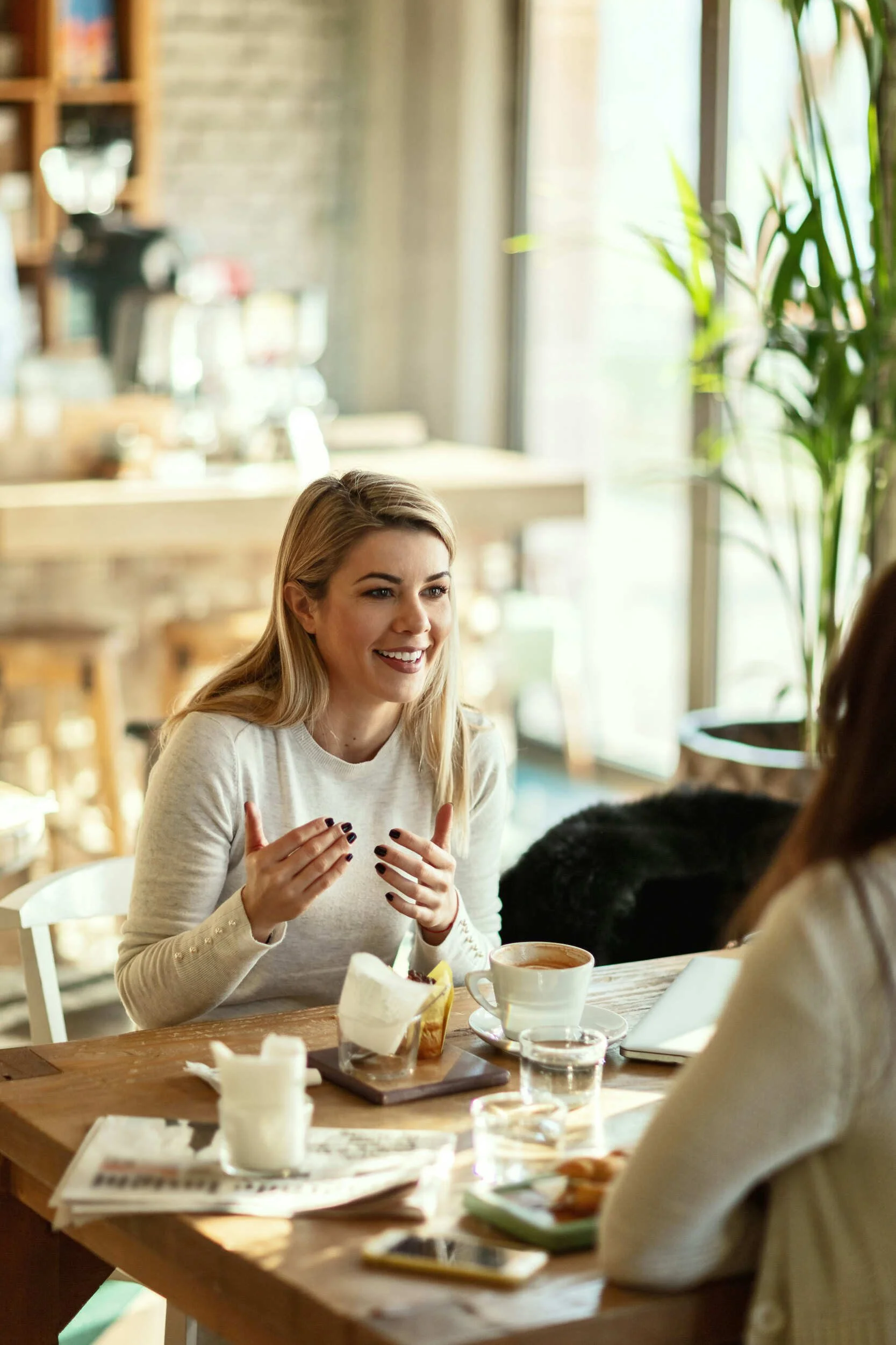 Two women talking inside over a coffee - career advice Phoenix