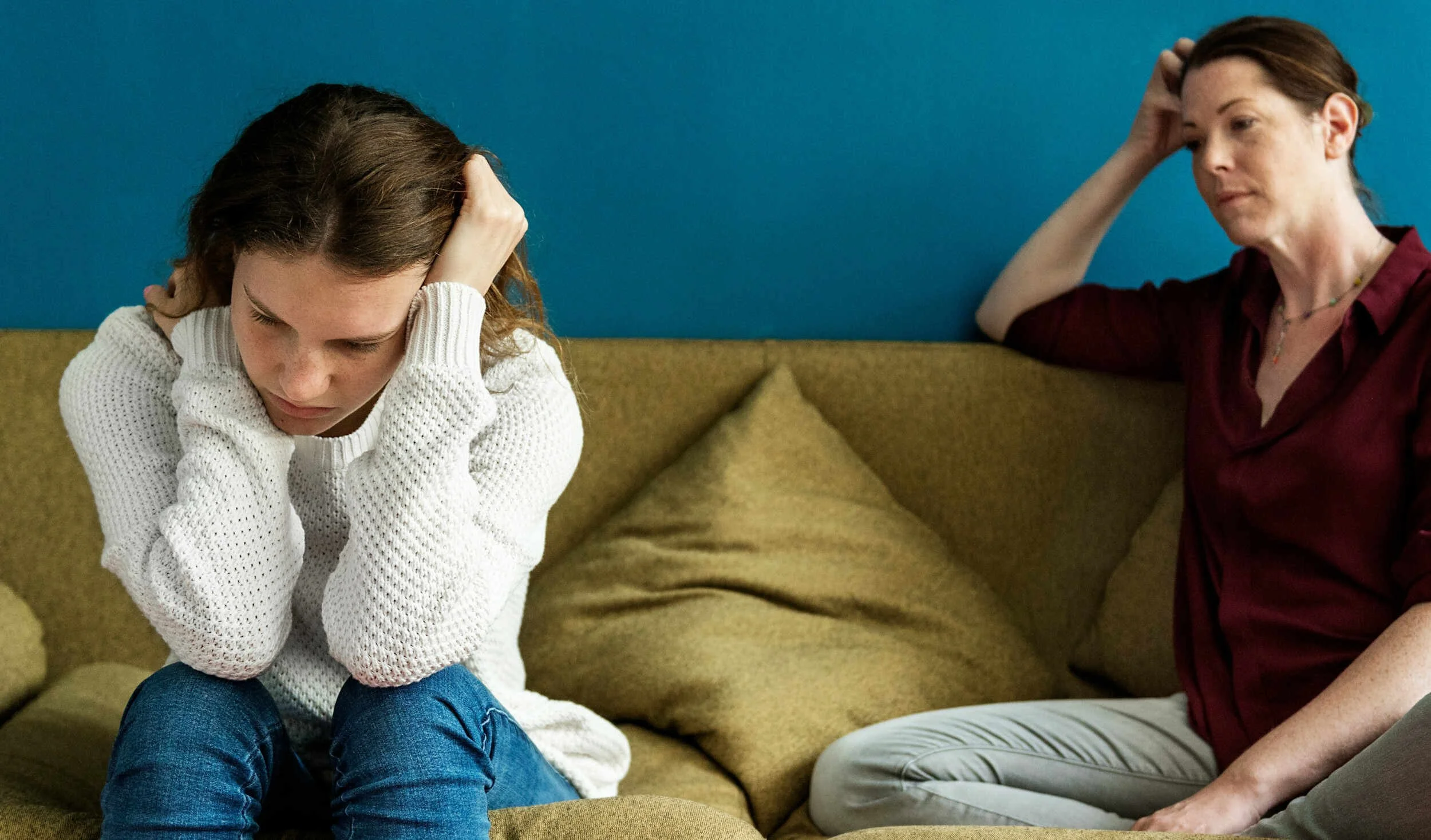 A young women with her mom sitting sad on a couch inside - Career Coaching Phoenix