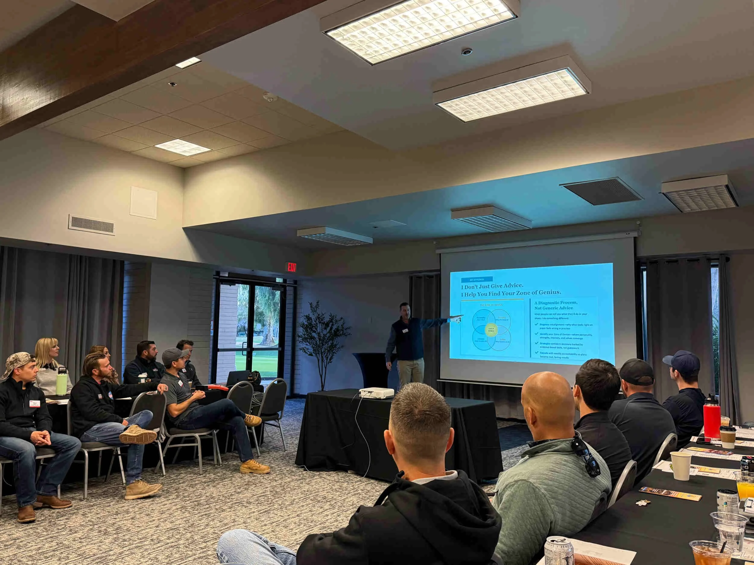 A man inside presenting to a group of people - career pivot from tech to coaching