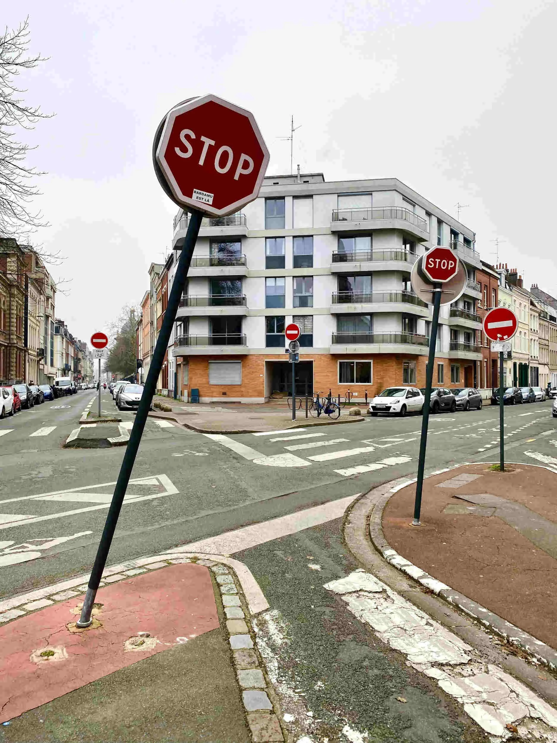 5 red street signs at an intersection of the road outside - overqualified for a job