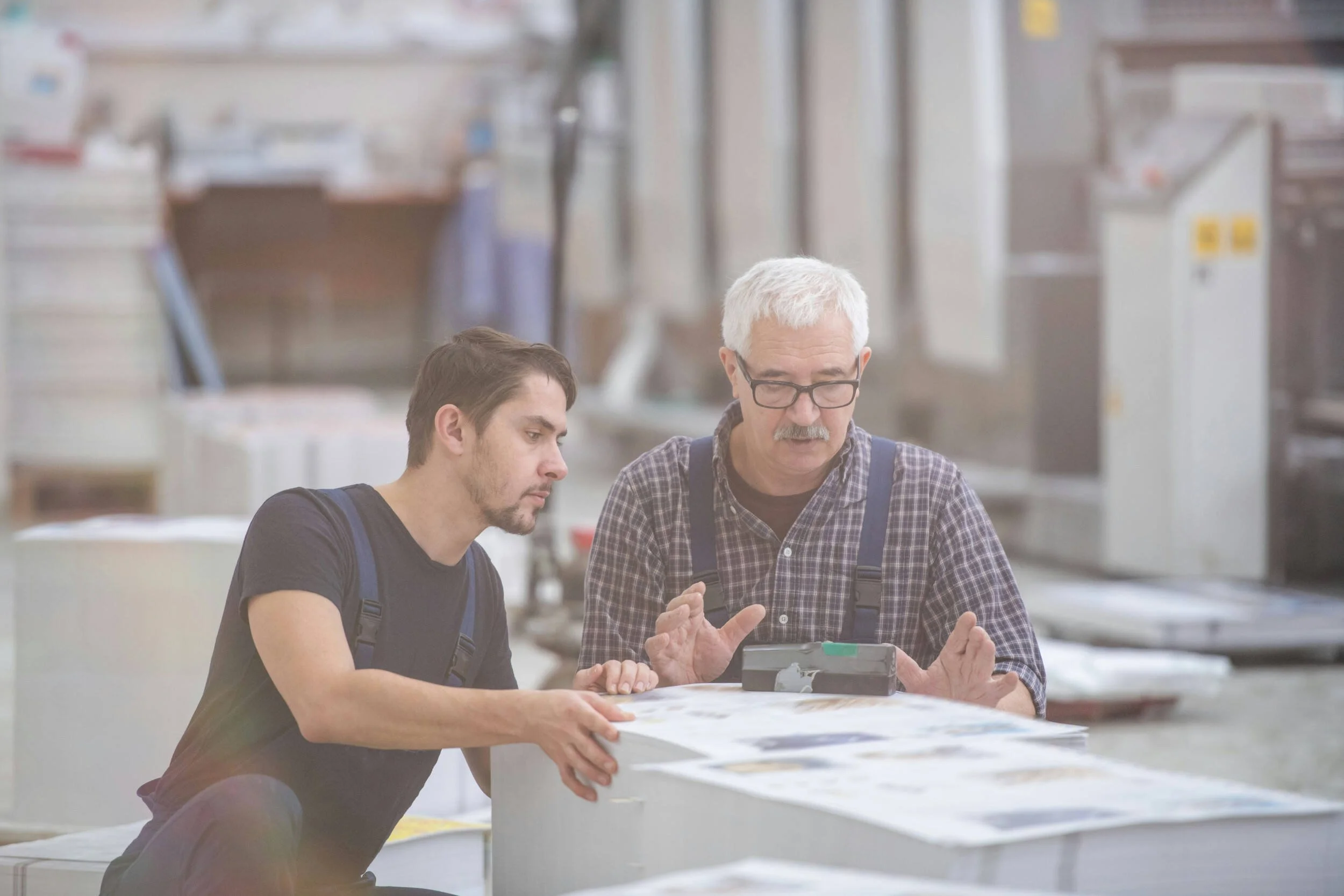 A younger man and older man sitting down working on something together - how to get unstuck in your career