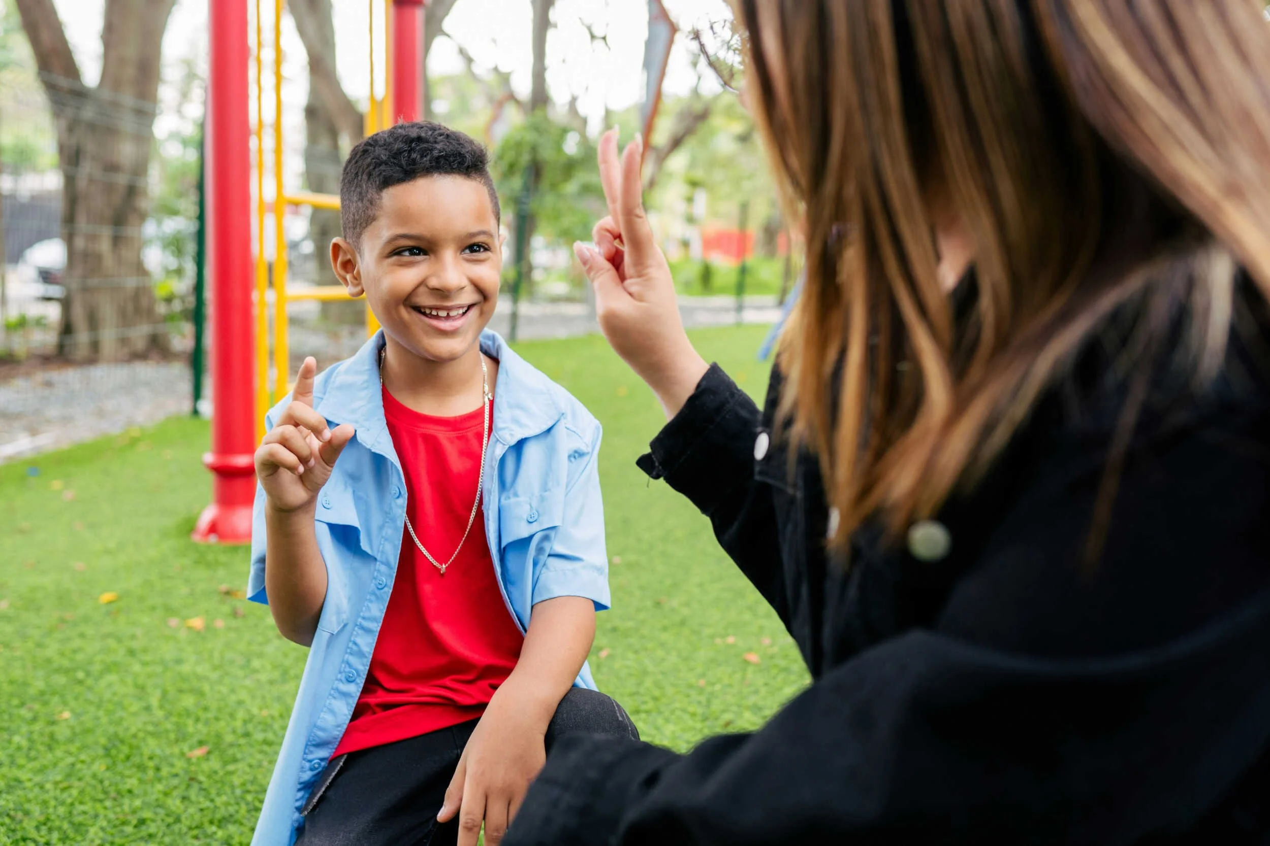 A young kid with a women in a outside park putting their hands up - how to figure out what you want