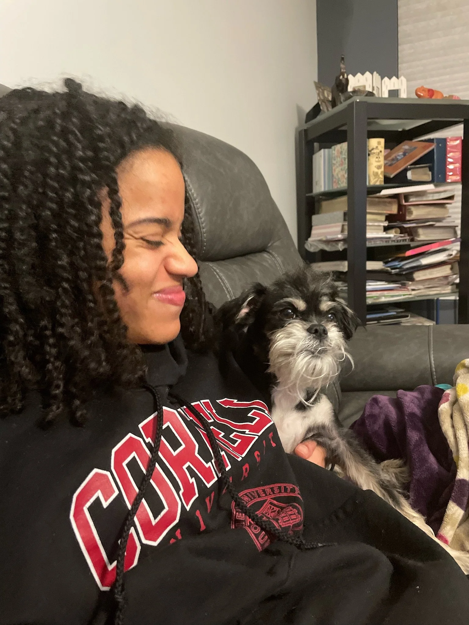 Mia sitting on the couch with a Brussels Griffon