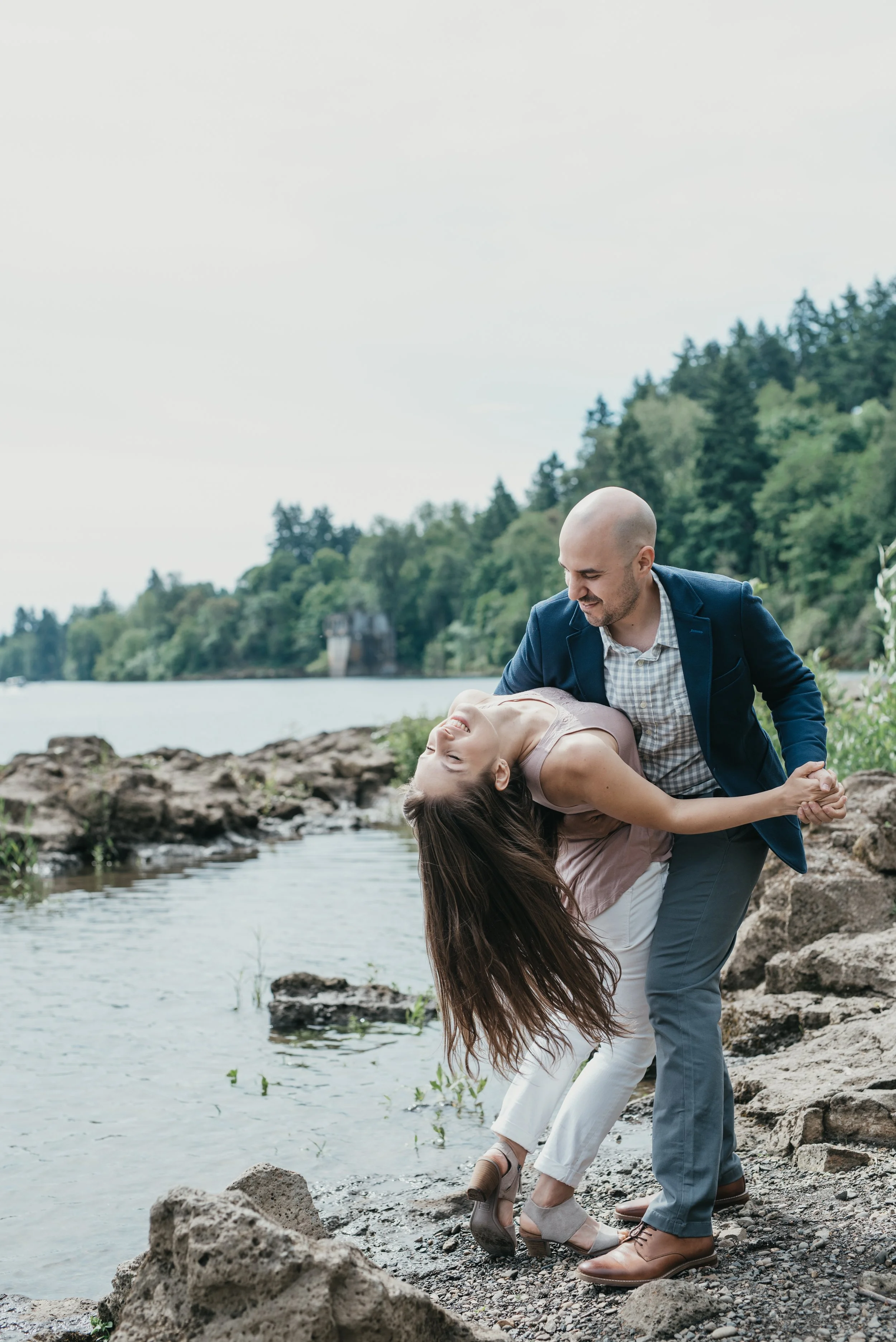 A male and a female dance on rocks joyfully