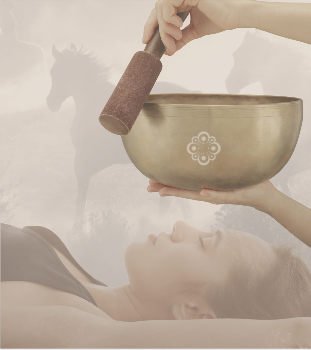 A woman lying down with eyes closed, holding a large singing bowl, while a person prepares to strike it with a mallet. There are horses in a misty landscape in the background.