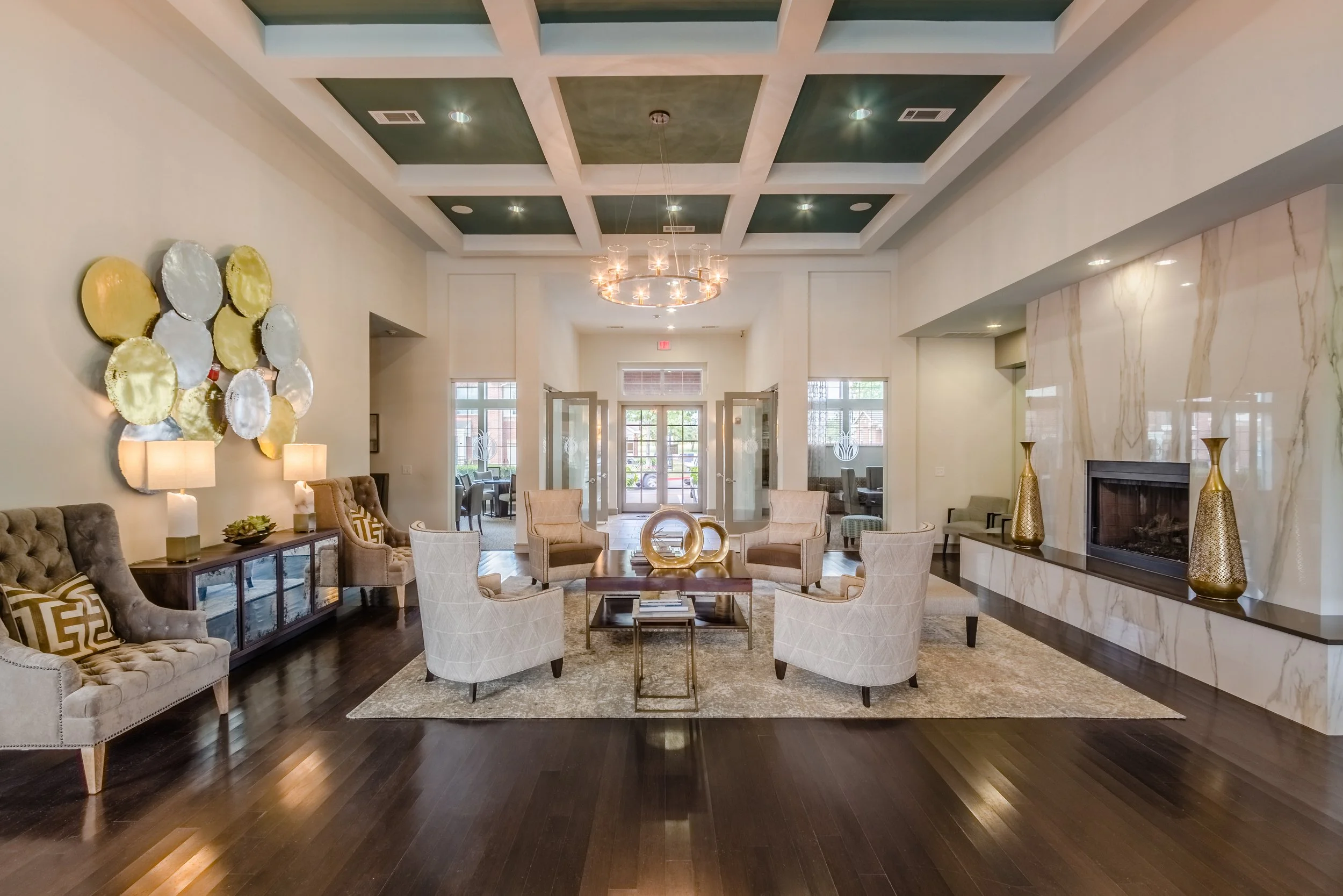 Elegant hotel lobby with seating area, fireplace, modern chandelier, and decorative vases.