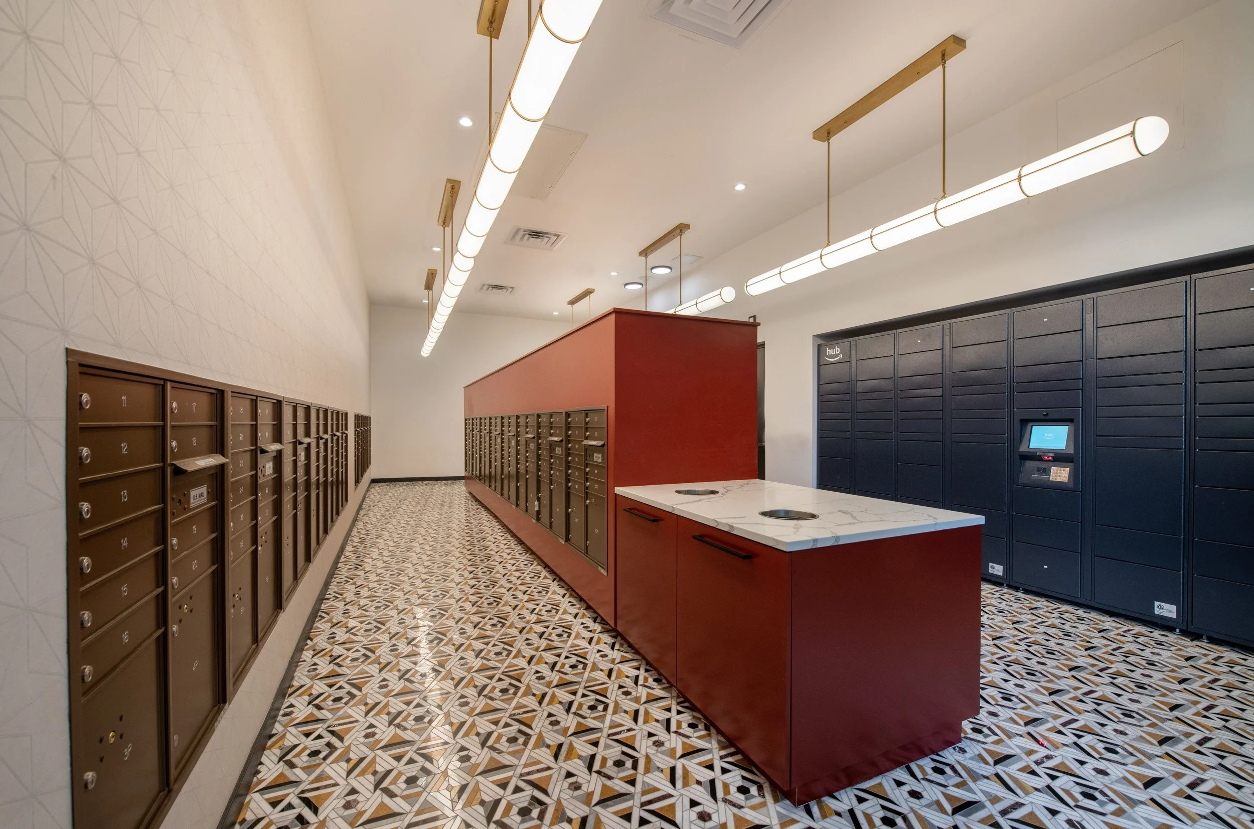 Lobby with brown and black mailboxes, a red parcel locker, and patterned tile floor.