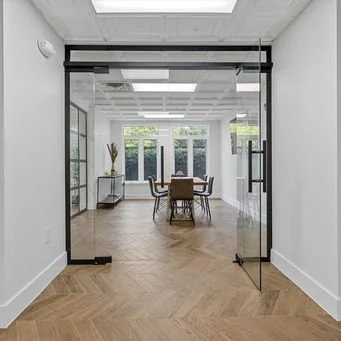 Empty room with glass sliding doors, a dining table and chairs, and large windows