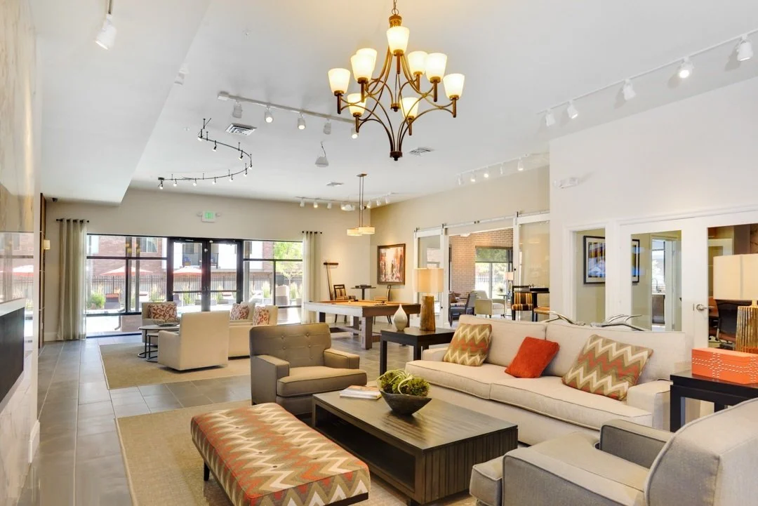 Spacious, well-lit lounge area with sofas, armchairs, a pool table, and large windows.