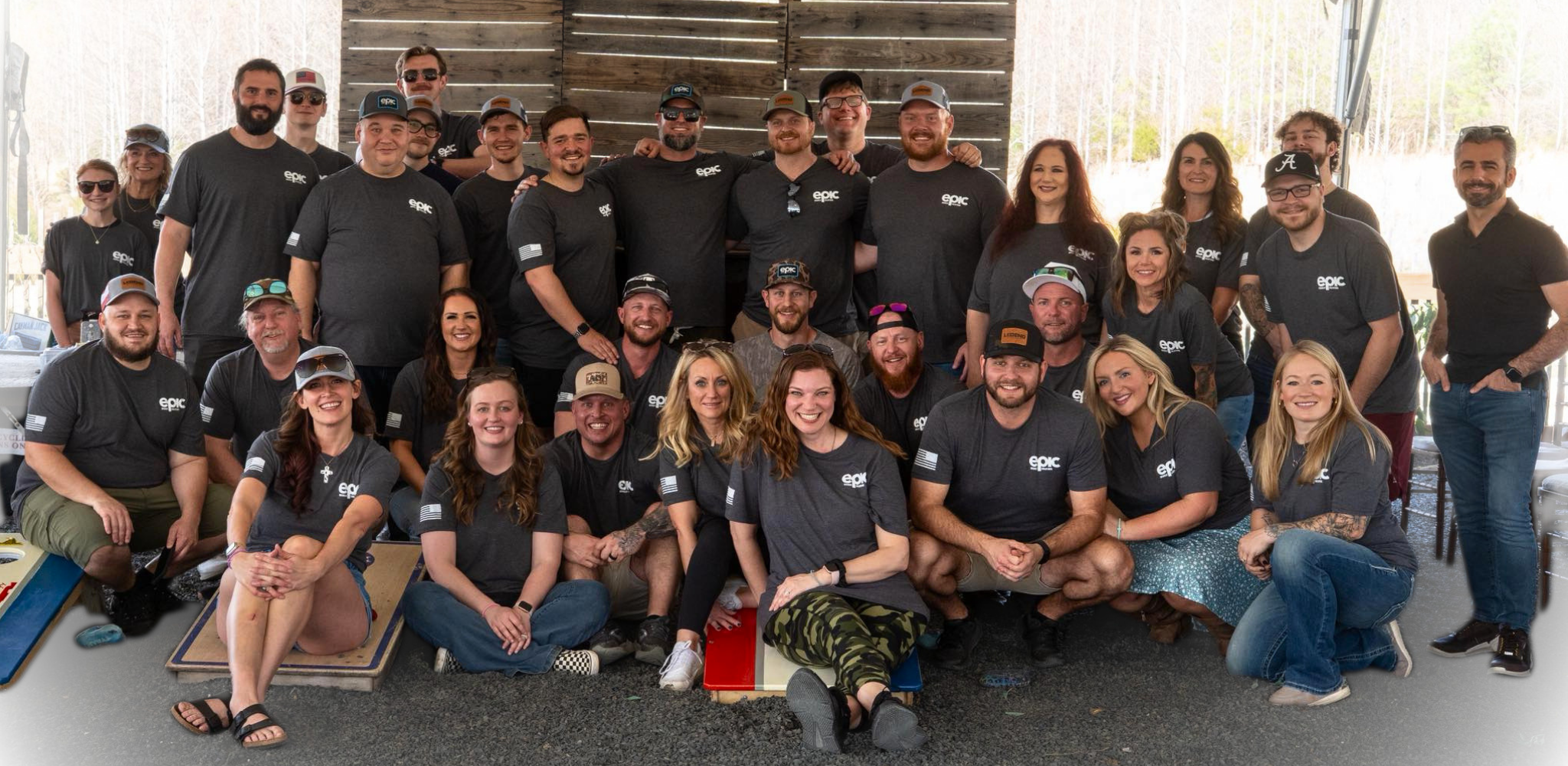 A large group of people, wearing matching black T-shirts with