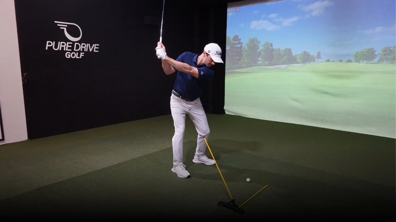 Adam Kolloff practicing golf swing with the Practice Glove in an indoor simulator.