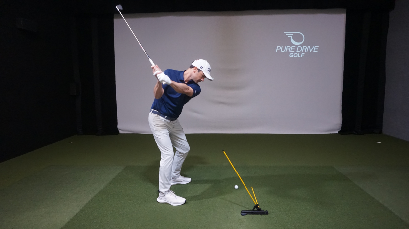 Adam Kolloff showing the Practice Glove and holding a golf club.