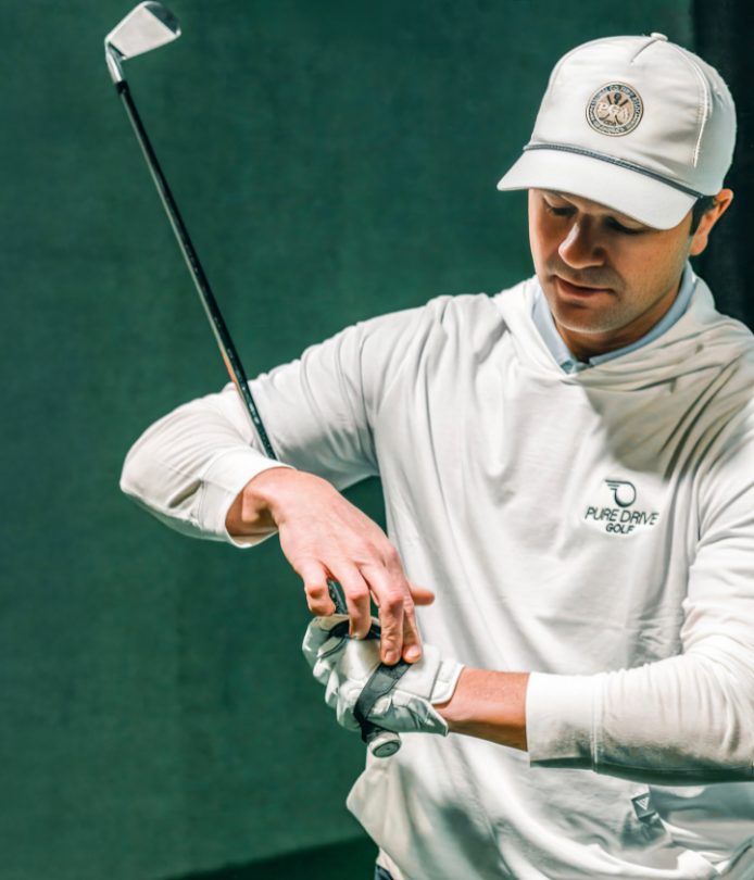 Adam Kolloff practicing golf swing with the Practice Glove in an indoor simulator.