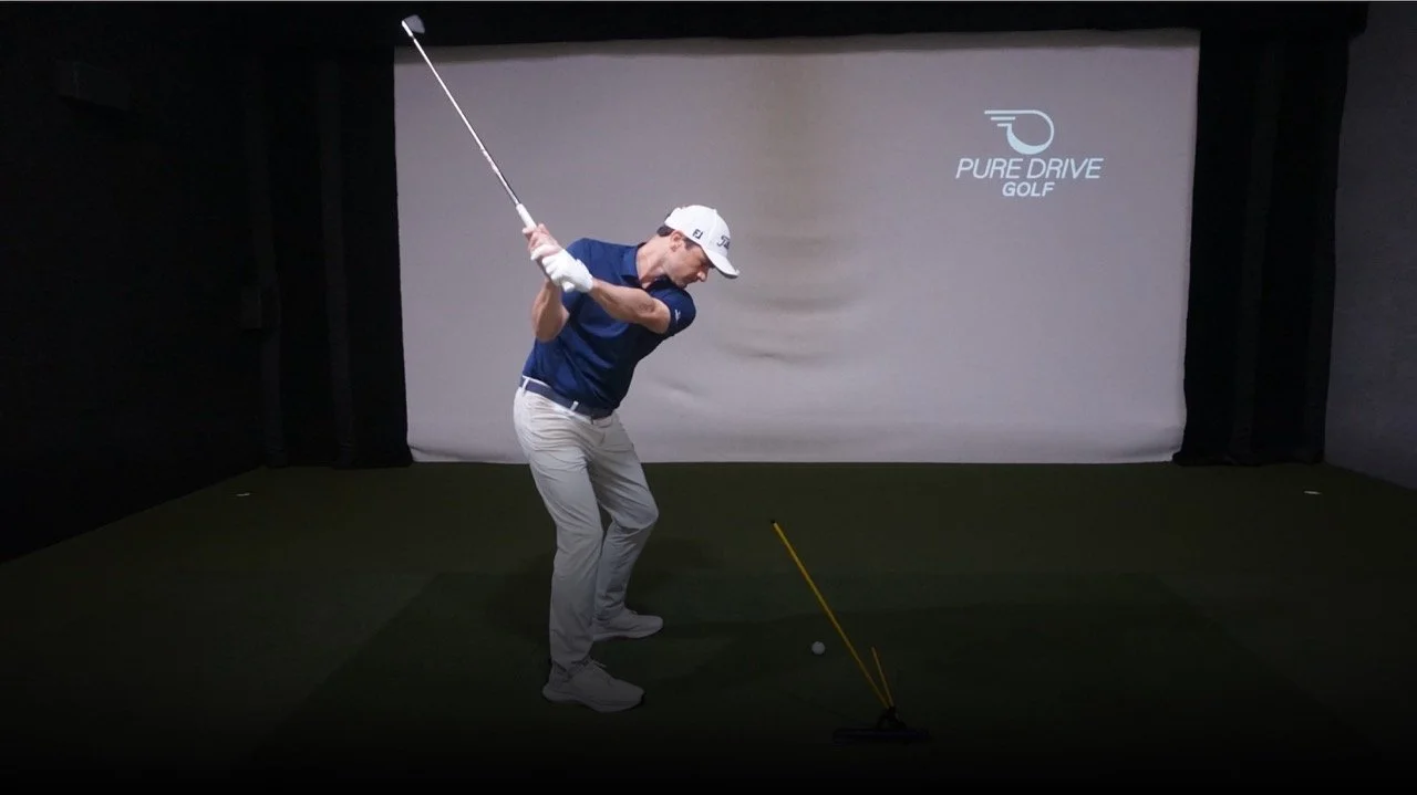 Adam Kolloff practicing golf swing with the Practice Glove in an indoor simulator.