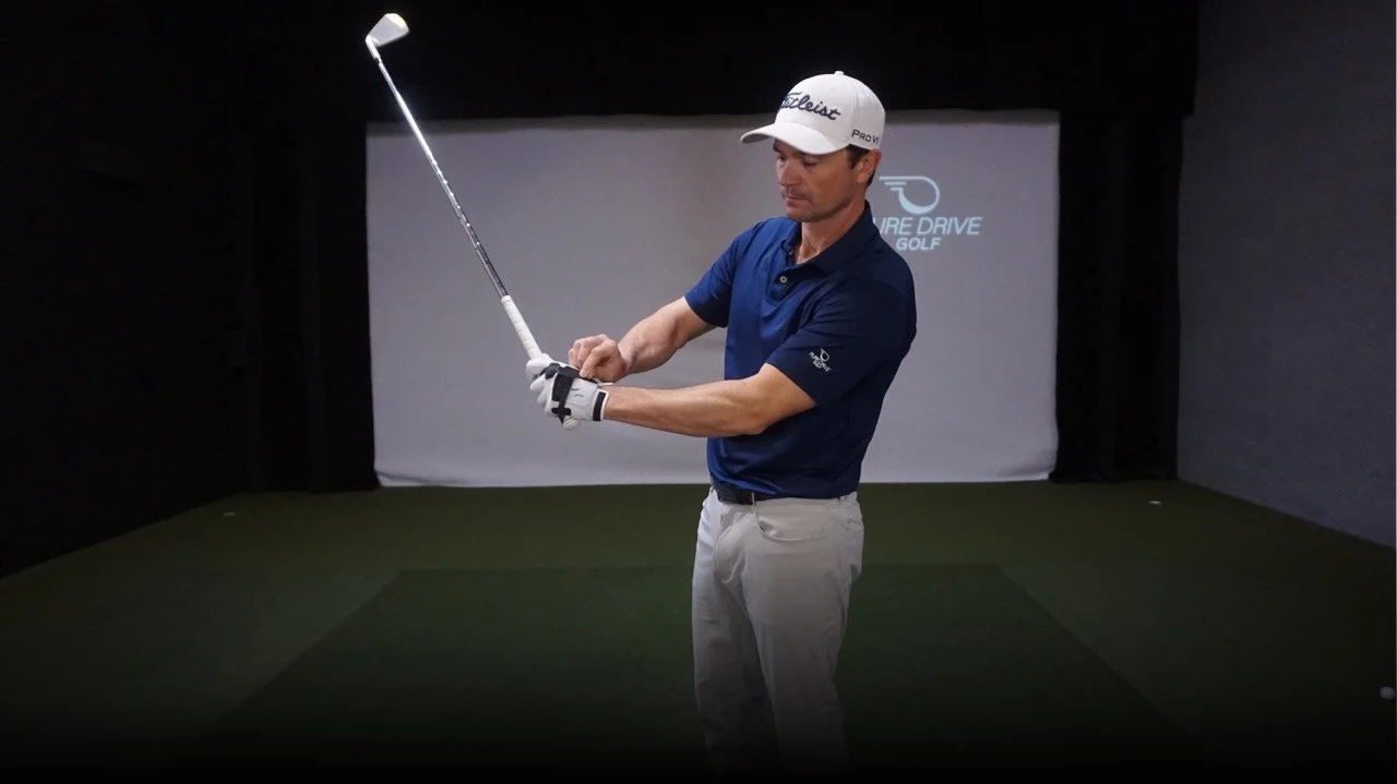 Adam Kolloff showing the Practice Glove and holding a golf club.