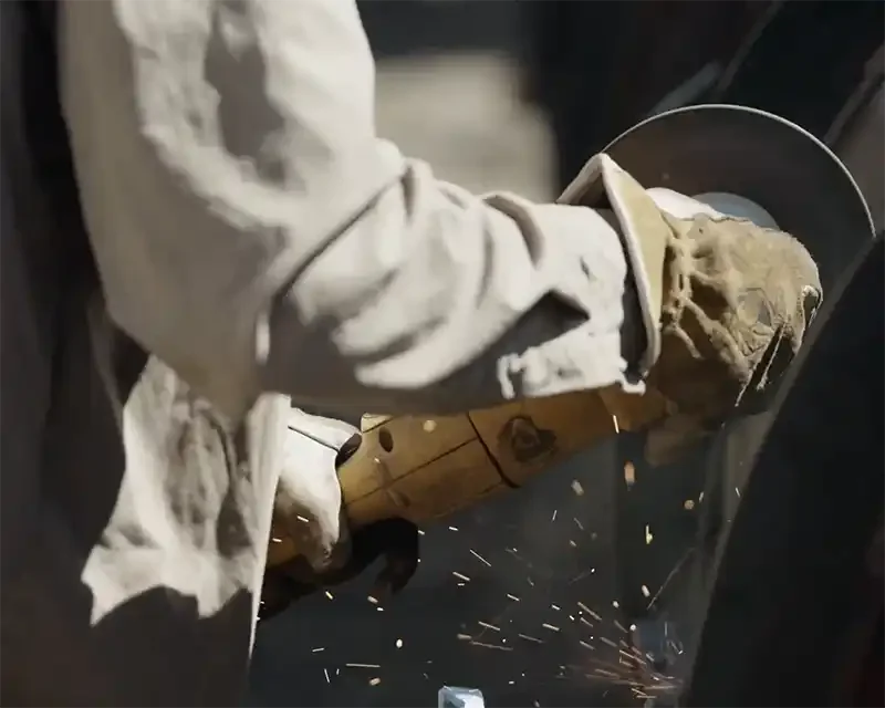 Field technician using a grinder during installation of methane capture and destruction infrastructure