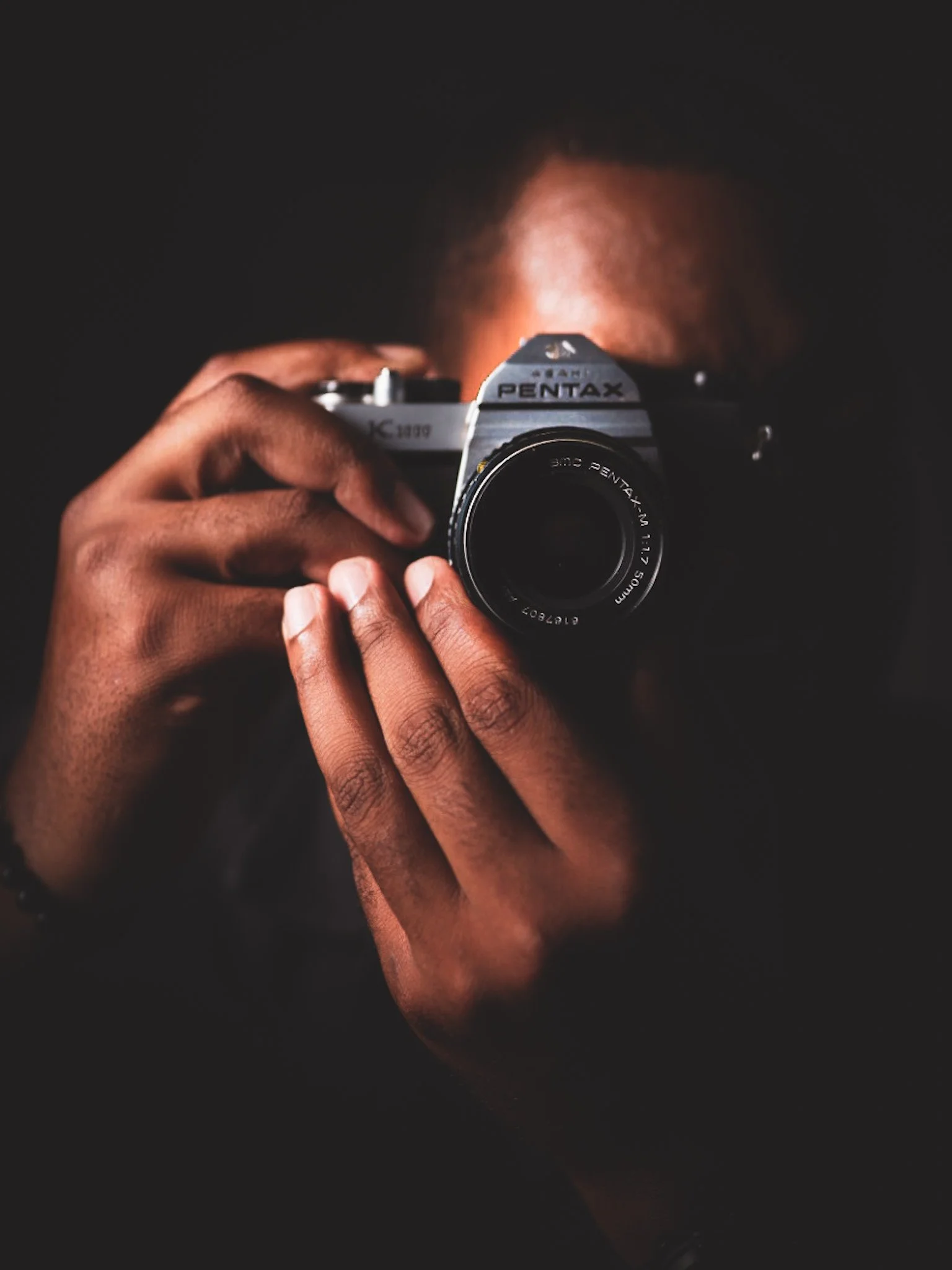 Thomas Mangum  & Makocr8s.com Creative director holding a vintage Pentax camera for a PR, marketing and visual storytelling portfolio.