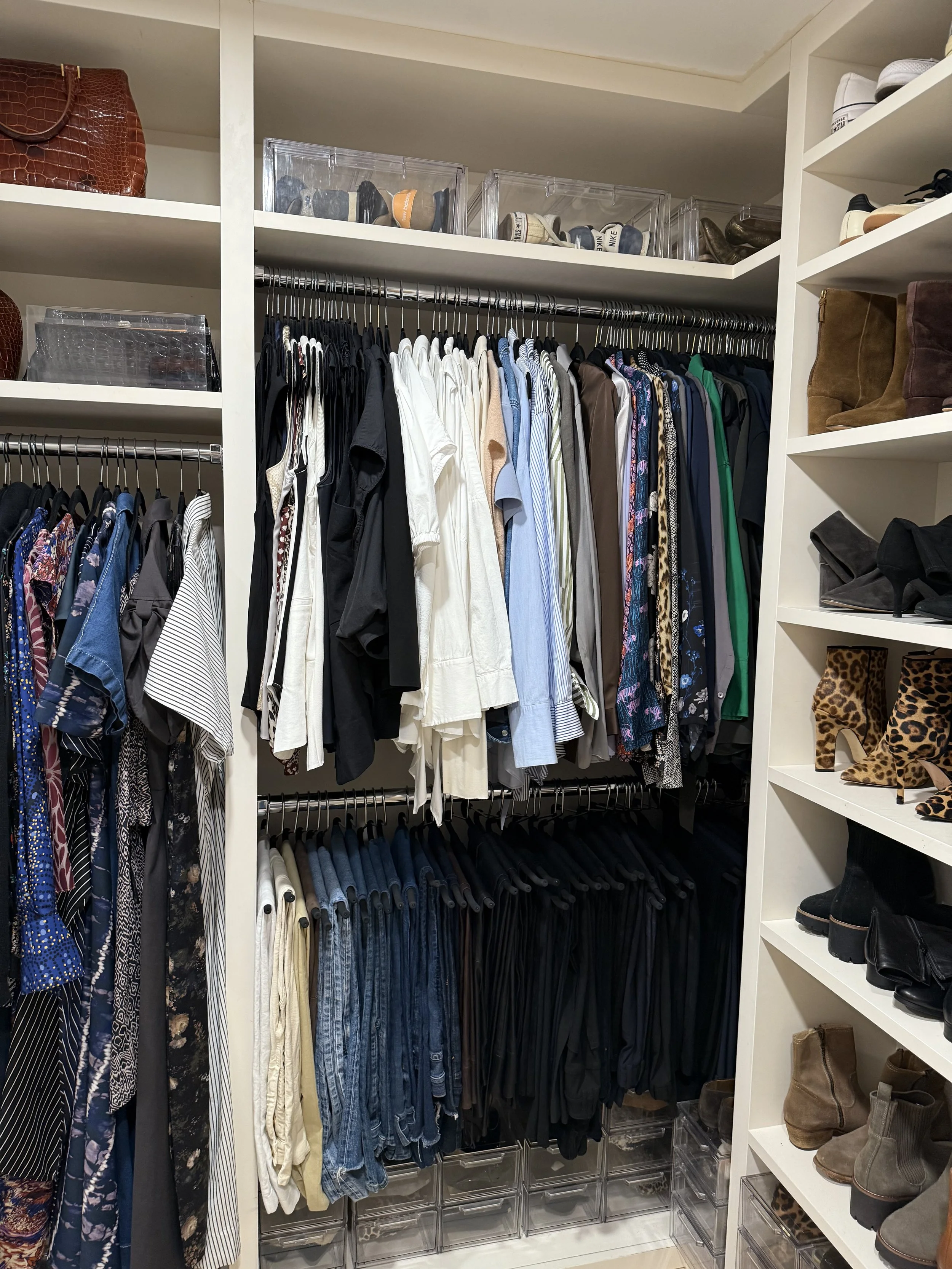 Closet with neatly organized clothing, shoes, and accessories in shelves and hanging rods.