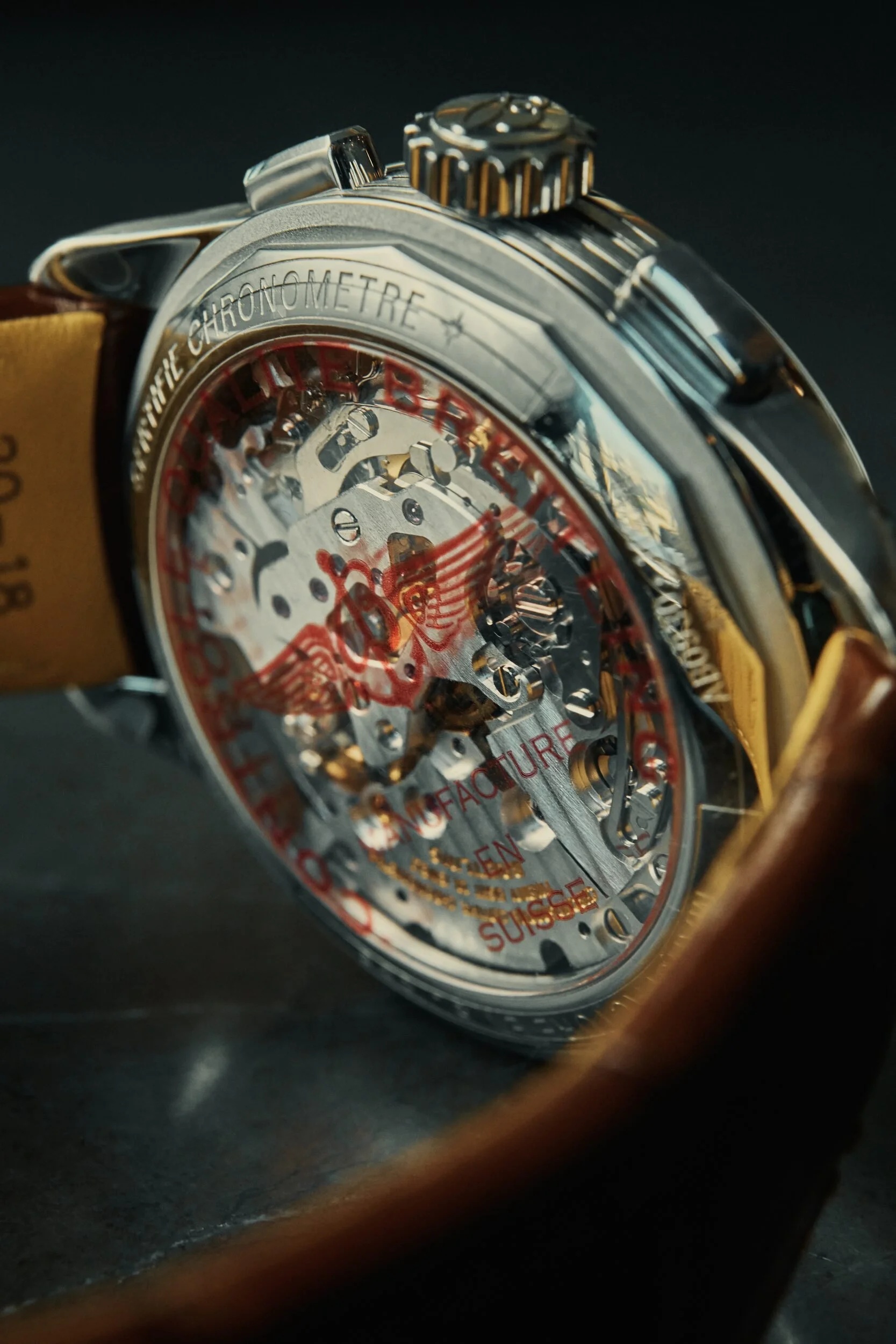 Close-up of a luxury wristwatch with a transparent face showing intricate mechanical components and red markings.