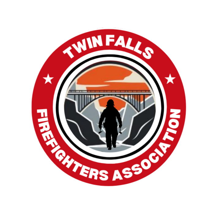 Logo of Twin Falls Firefighters Association featuring a firefighter silhouette walking through a canyon with a bridge and sunset in the background, surrounded by a red border with white text.