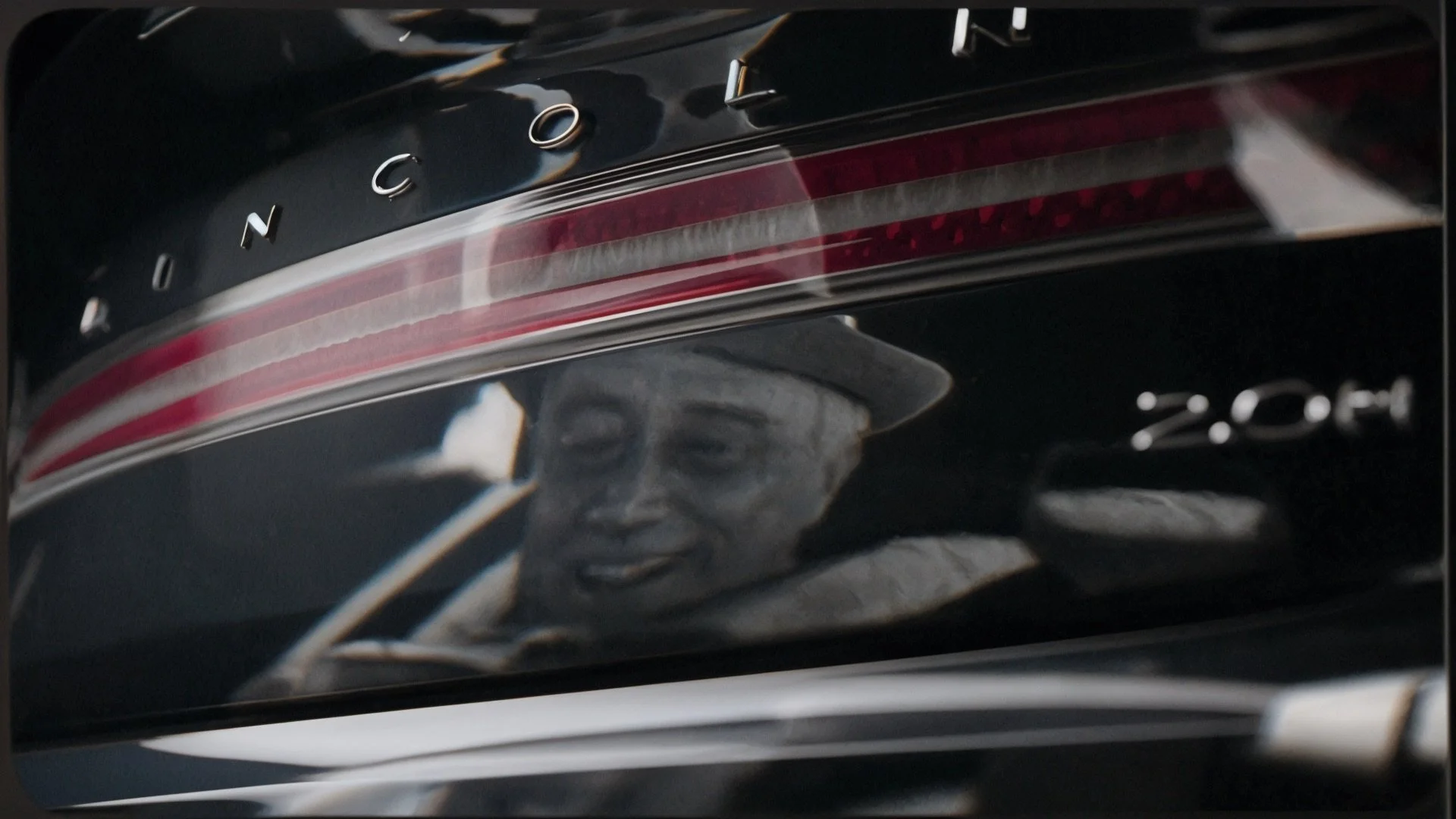 Close-up of a black car with Chrome letters spelling 'ROCKET' on the rear. A decal of a smiling woman wearing a hat and holding a cigarette is visible on the back of the car.