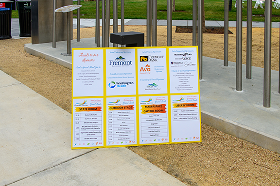 Signboard with directory and sponsor logos at a park or outdoor public space.